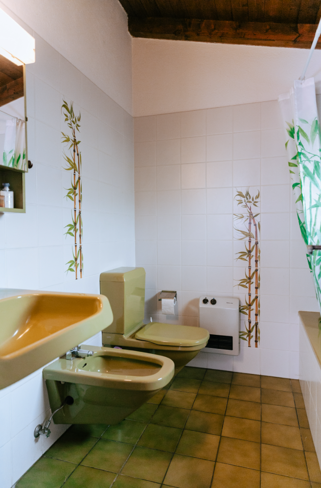 Kleines Badezimmer mit Holzdecke und grünlich-beigen Sanitärkeramiken