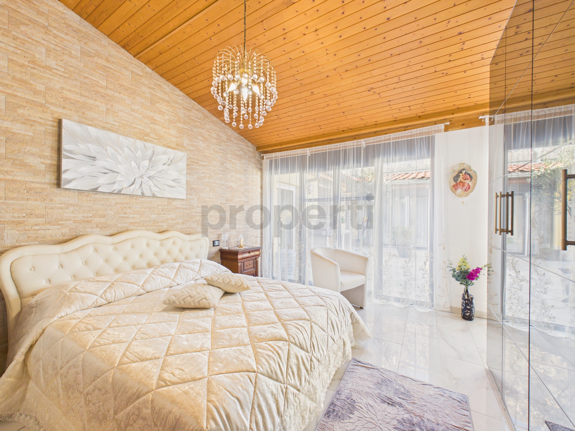 Luxuriöses Schlafzimmer mit hohem Holzdeckengewölbe