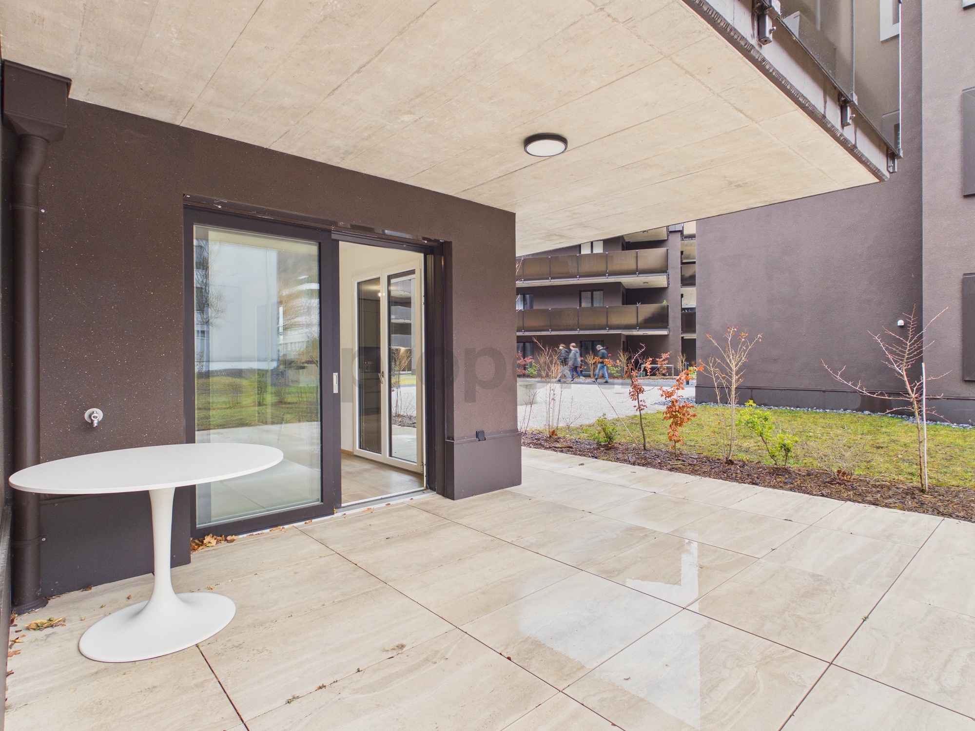 Überdachte Terrasse eines modernen Mehrfamilienhauses