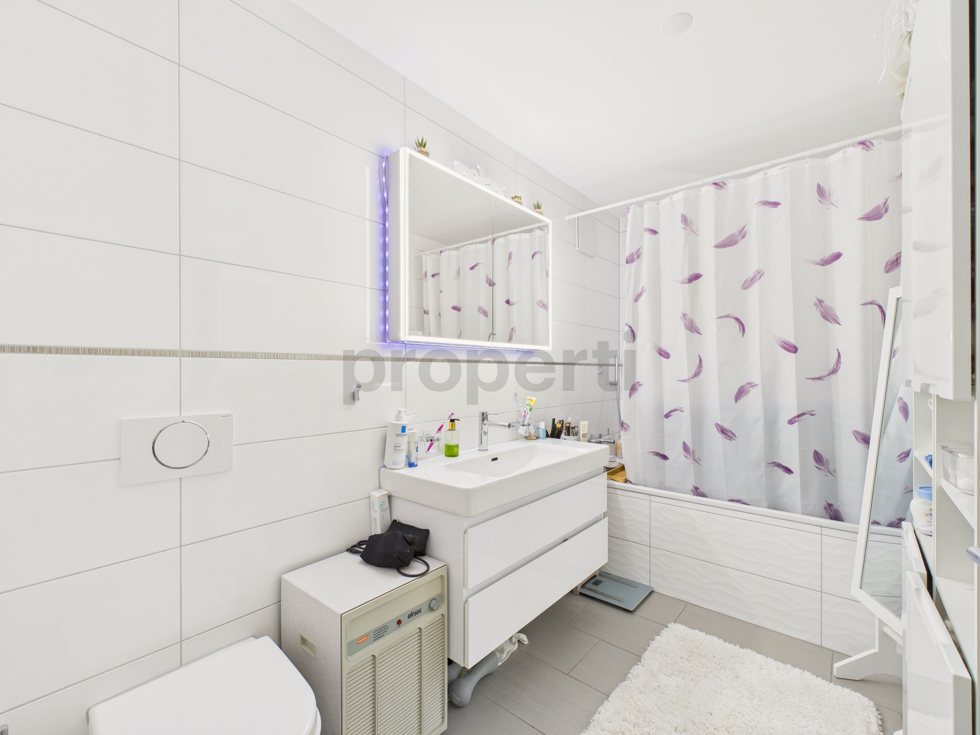 Helles, modernes Badezimmer mit Badewanne und Waschtisch