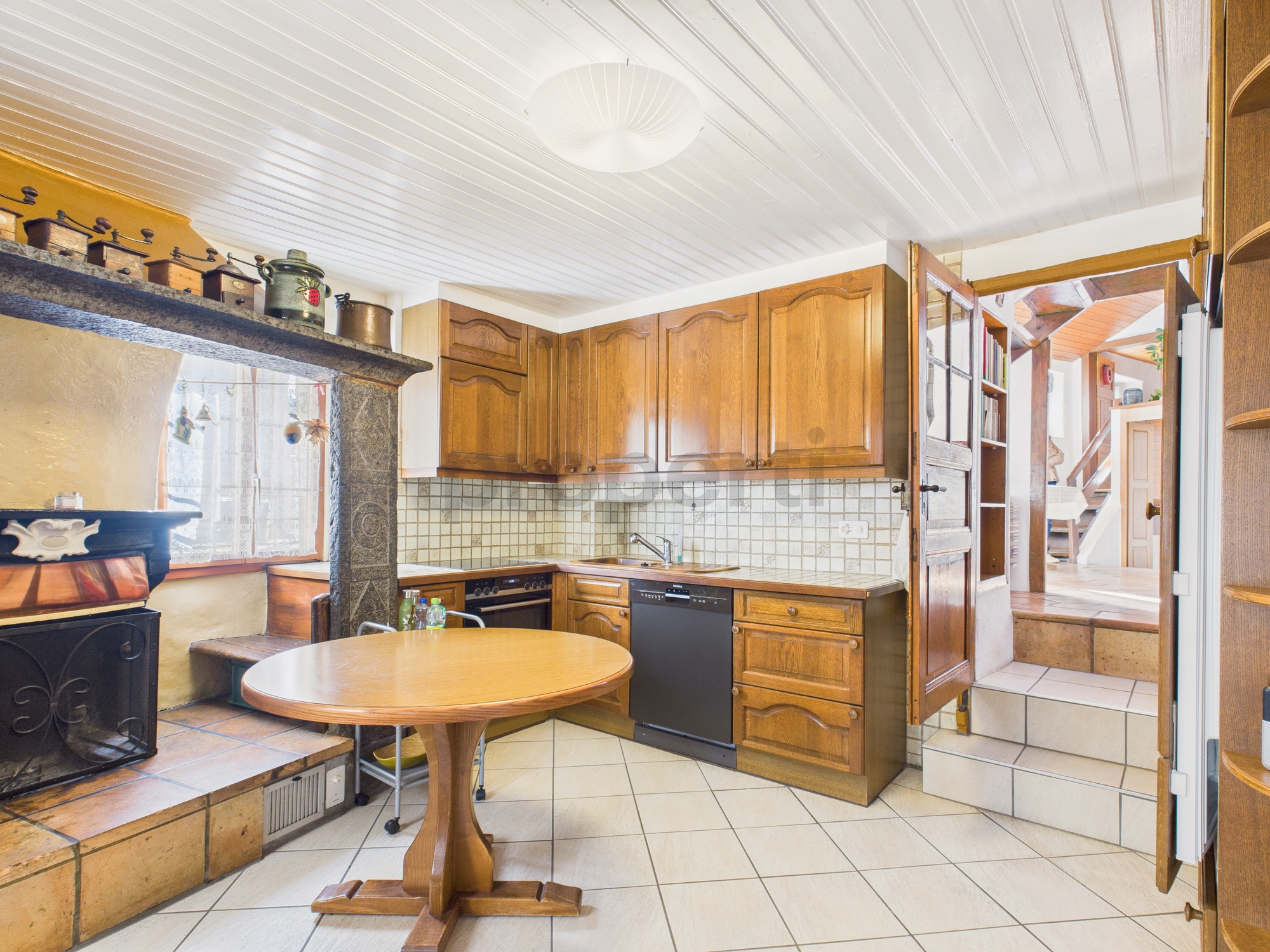 Rustikale Küche mit Holzfronten und Kamin