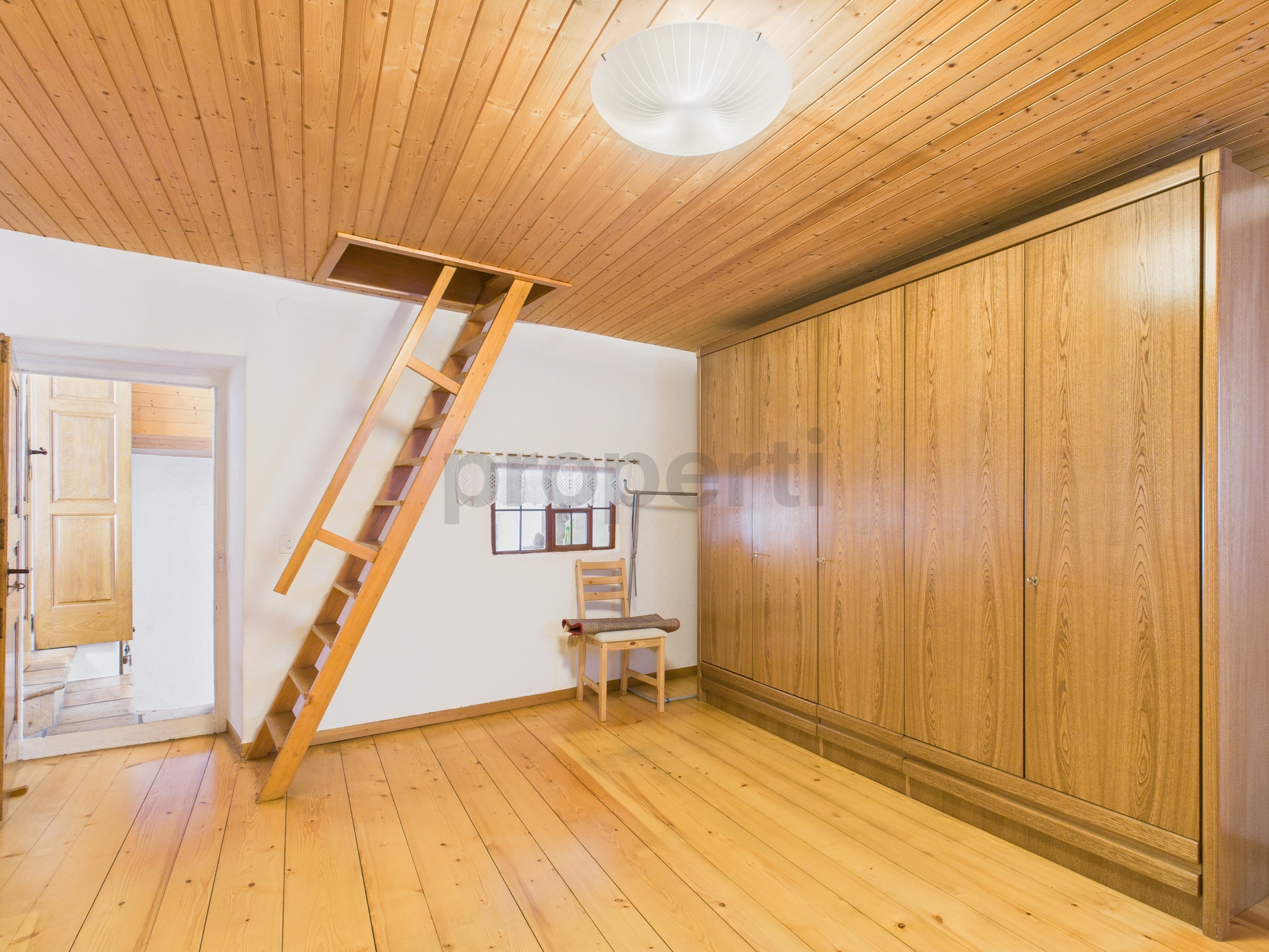 Dachzimmer mit Leiter und Einbauschrank