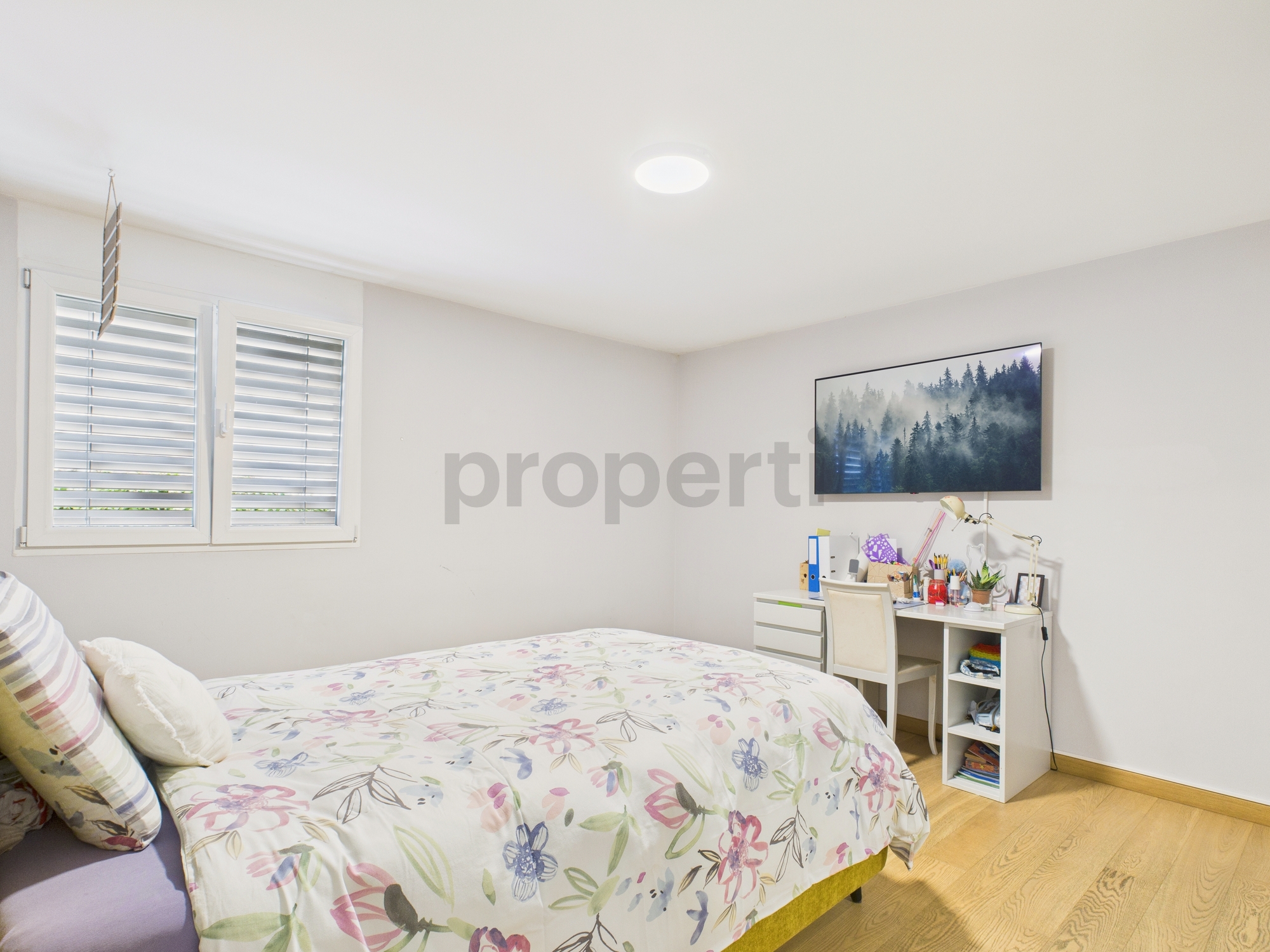 Helles Schlafzimmer mit Fenster und Schreibtischecke