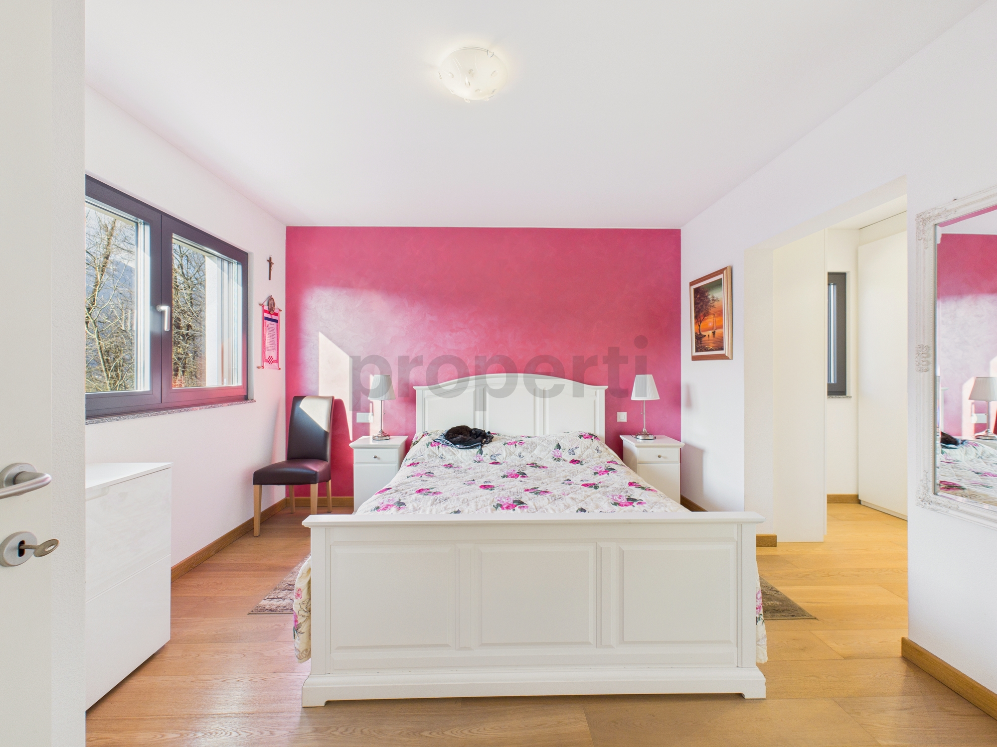 Helles Schlafzimmer mit pinker Akzentwand