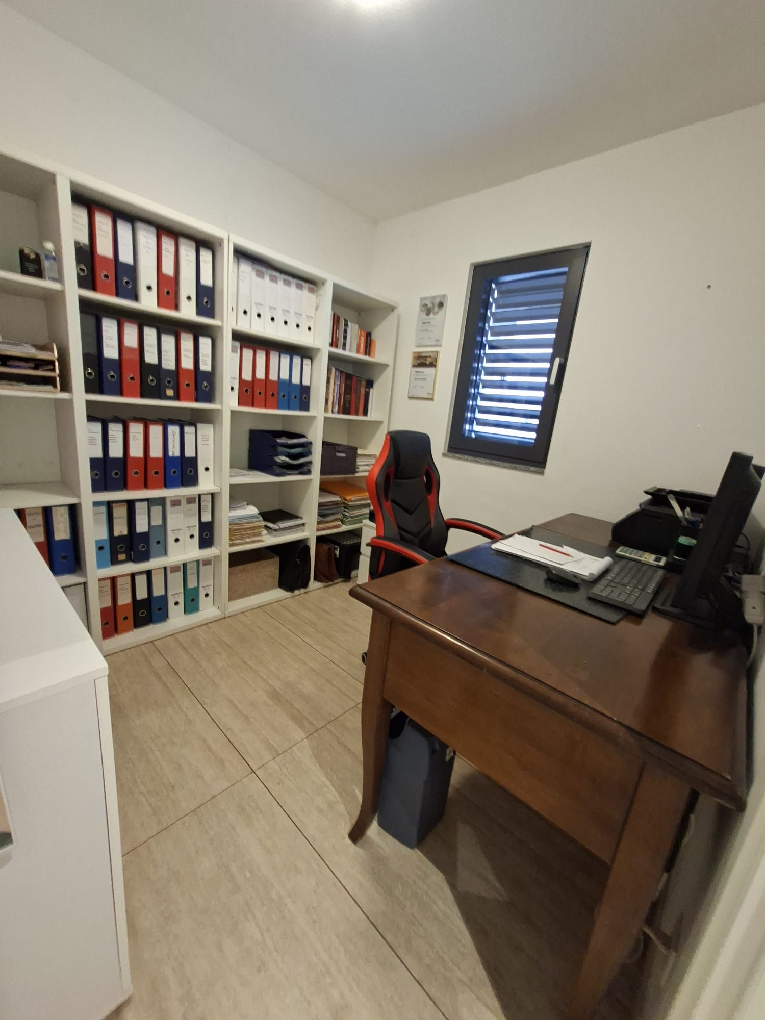 Büro- bzw. Arbeitszimmer mit Regalen und Schreibtisch