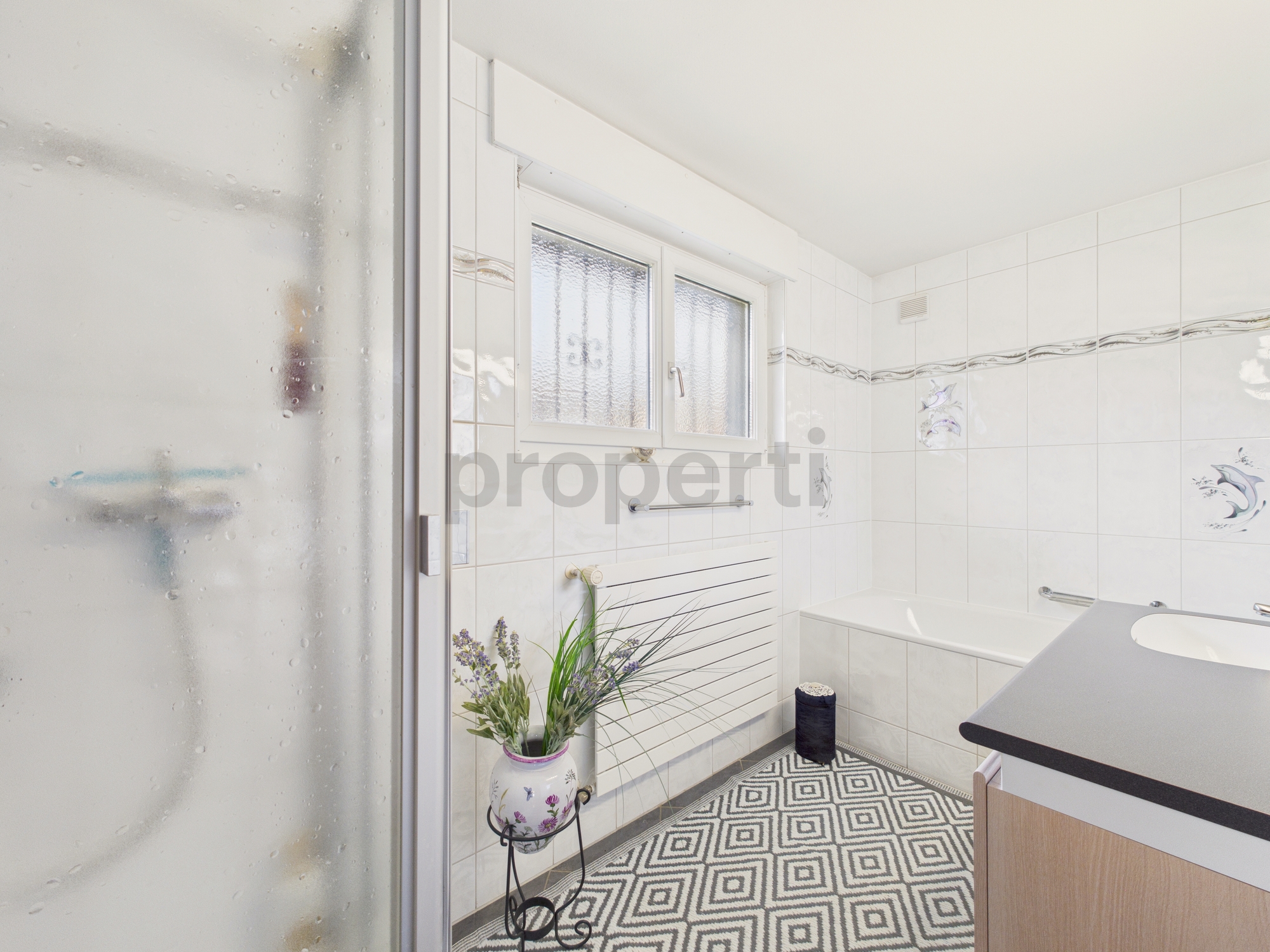 Helles Badezimmer mit Wanne und Fenster