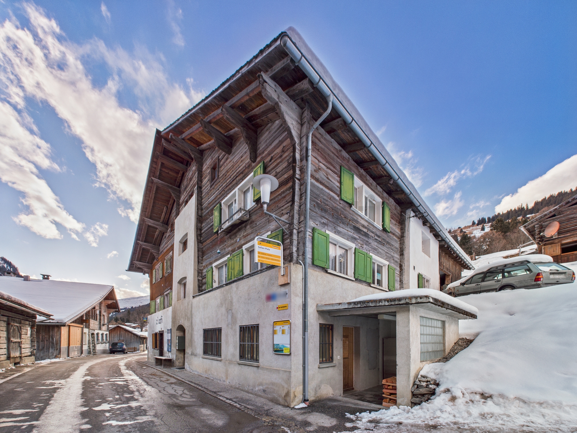 Alpenhaus an verschneiter Straße