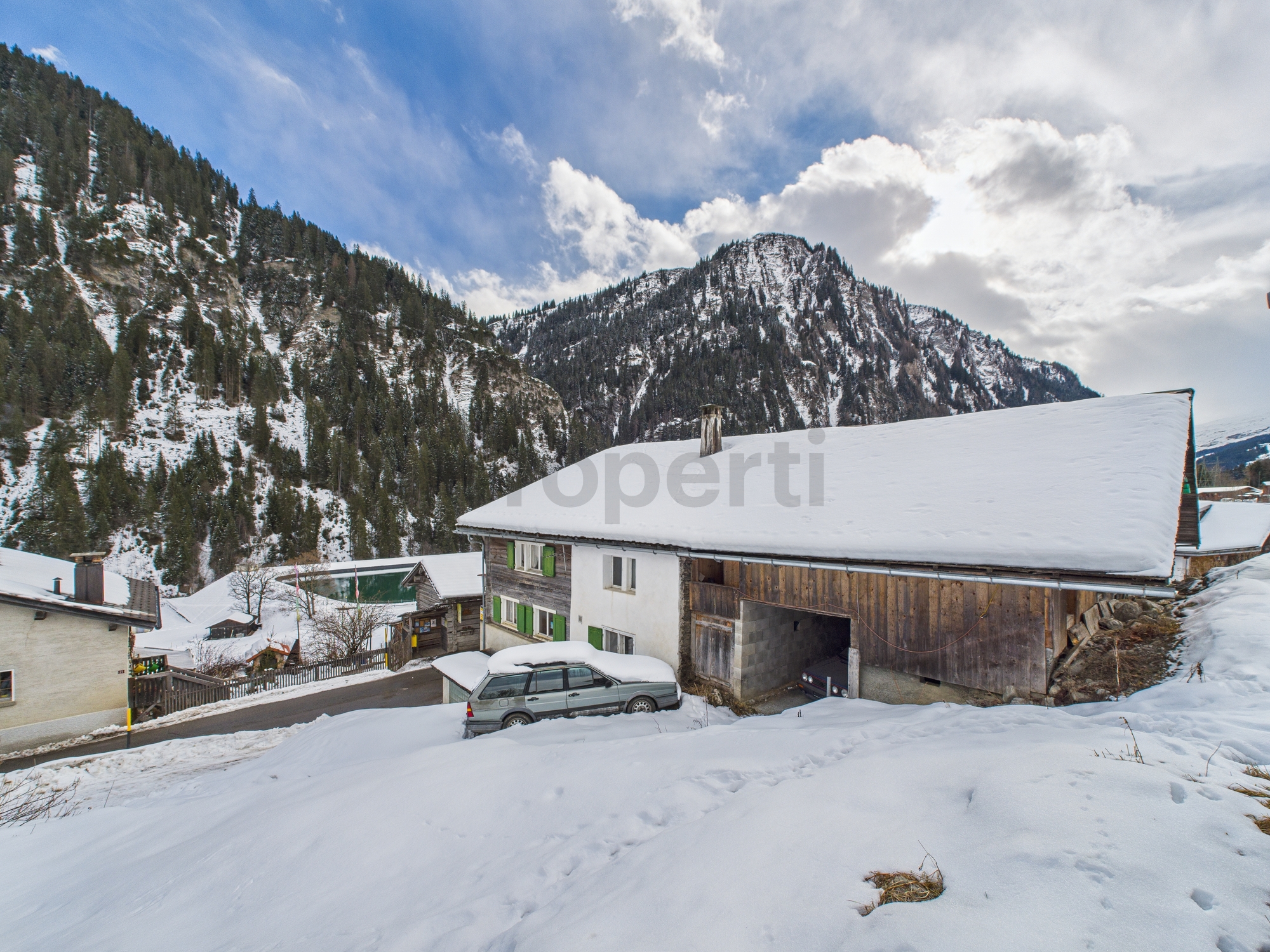 Verschneites Berghaus mit Tal- und Bergblick