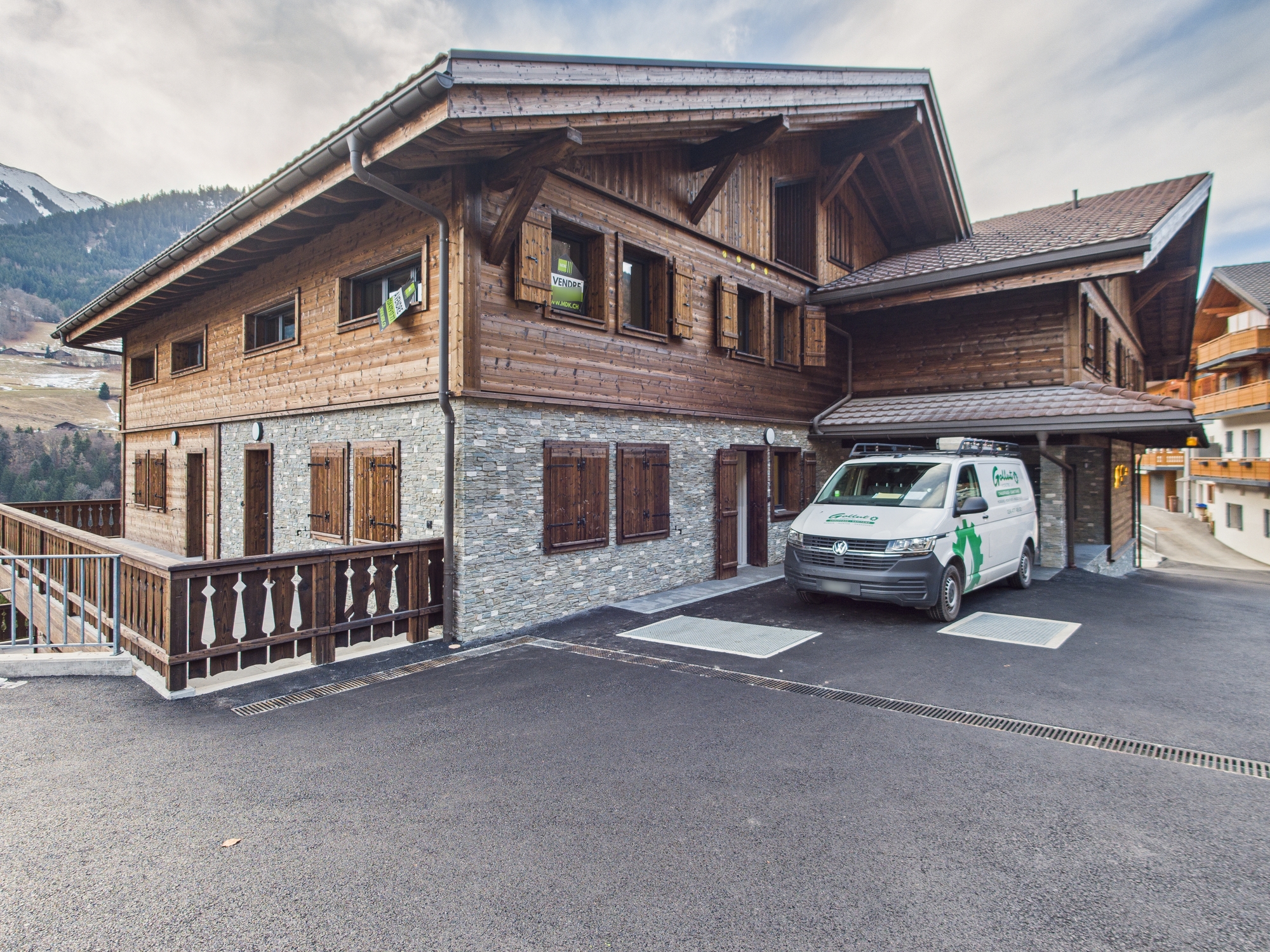 Alpines Holzhaus mit Steinfassade und Carport
