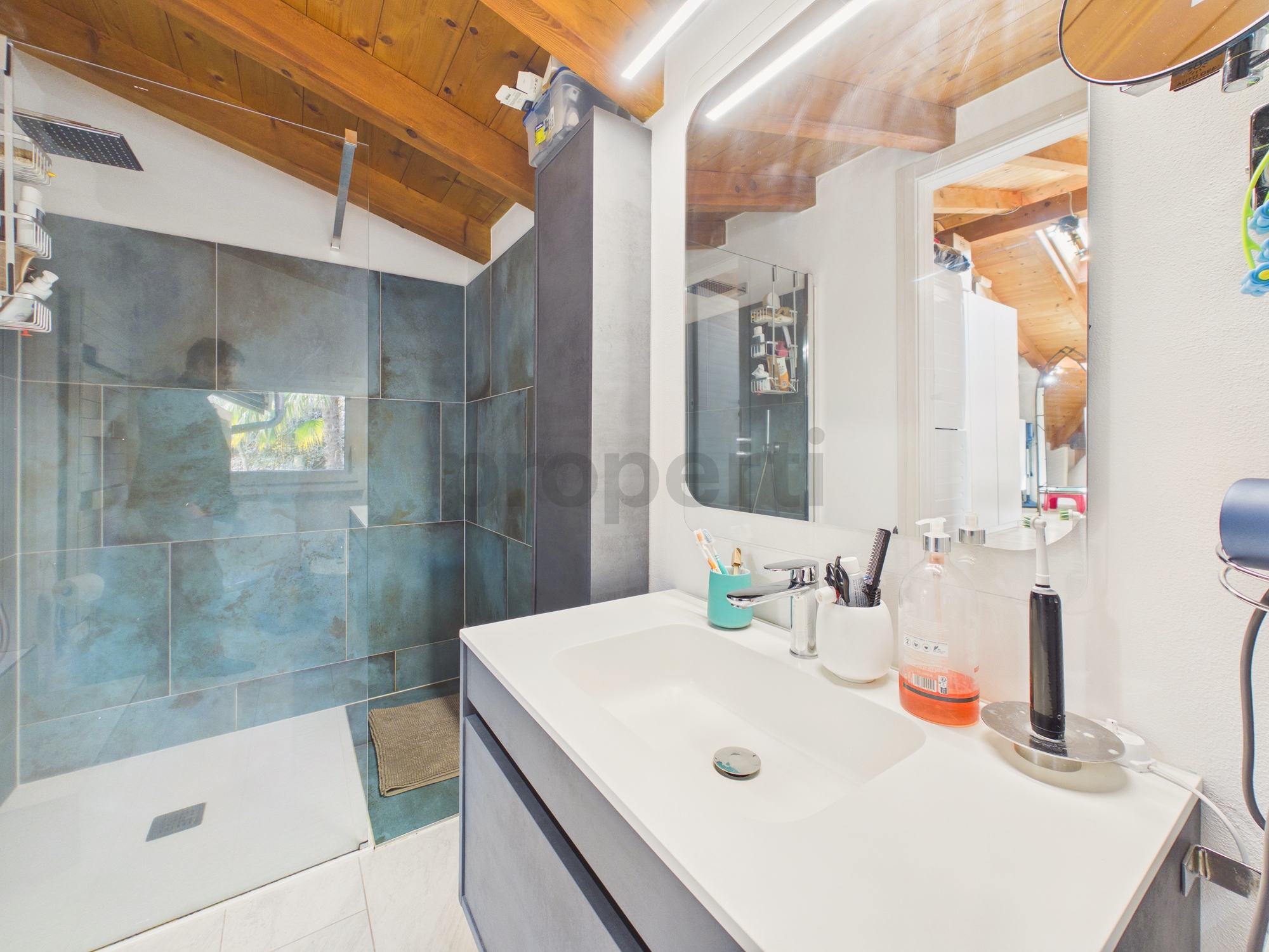 Modernes Badezimmer mit Holzdecke und Glasdusche