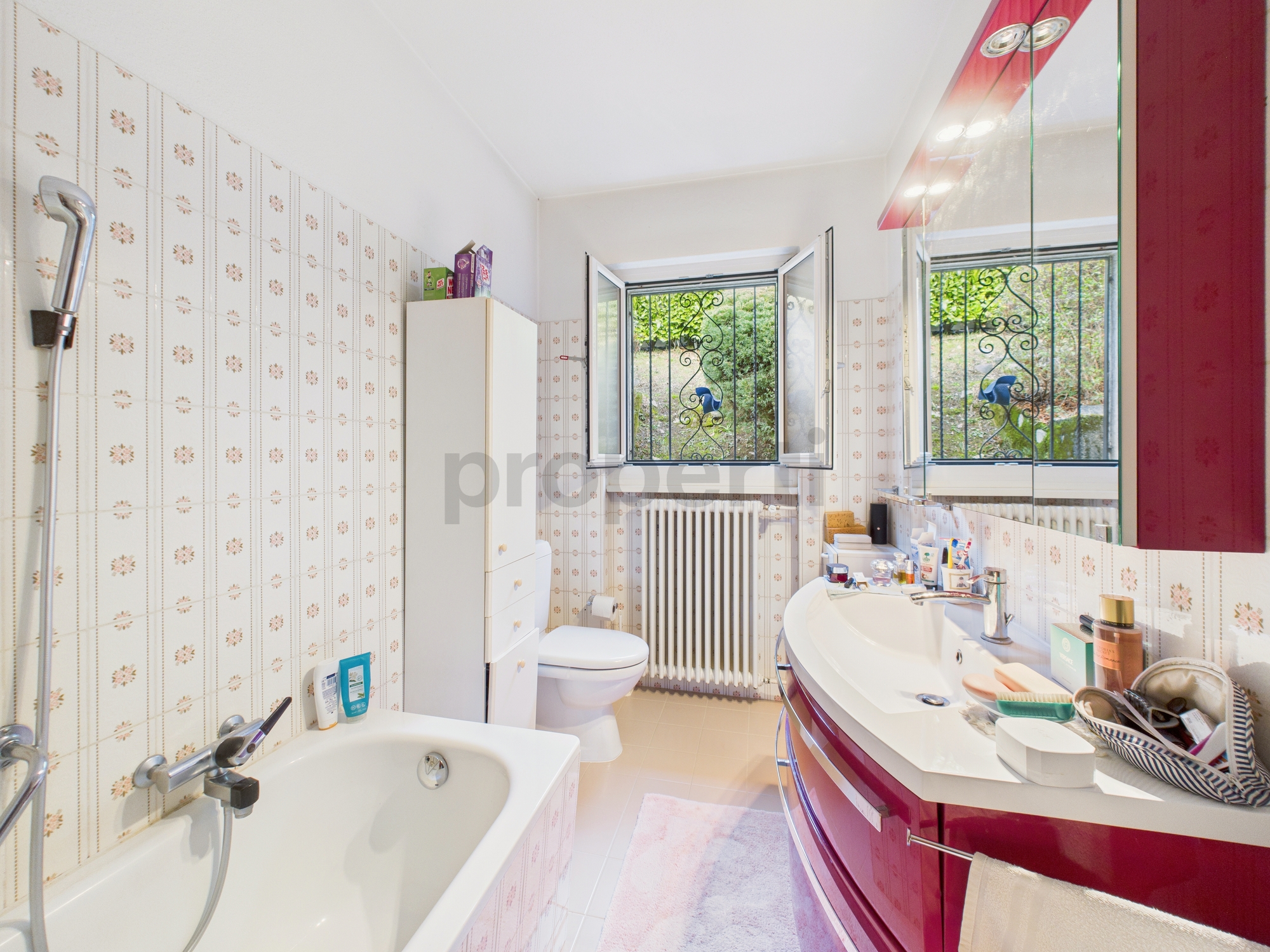 Helles Badezimmer mit Badewanne, Fenster und Waschtisch