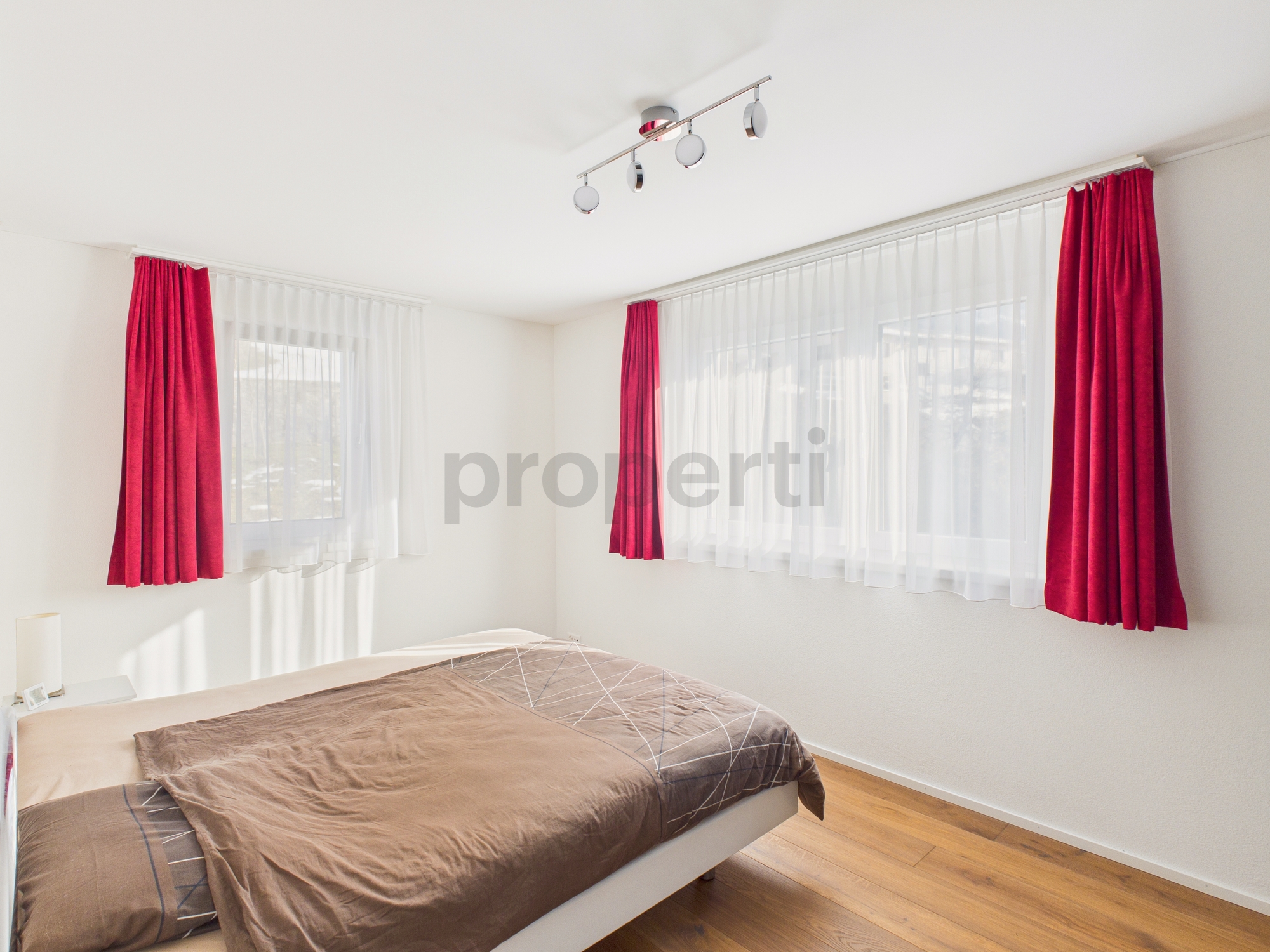 Helles Schlafzimmer mit rotem Vorhang
