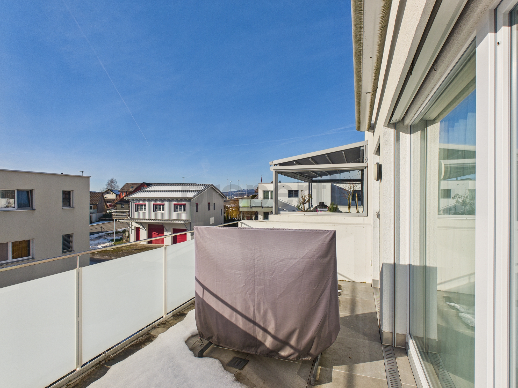 Balkon mit Glasgeländer und Markise