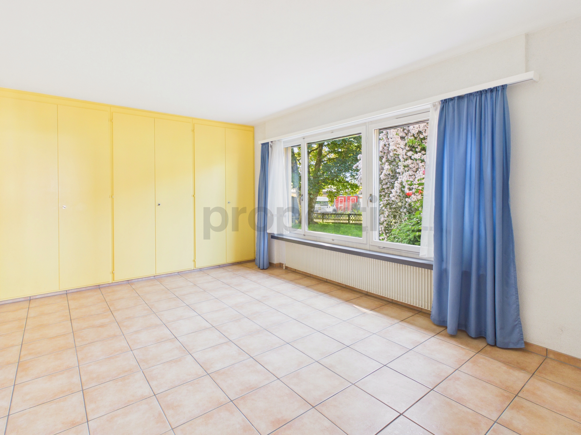 Heller leerer Raum mit Einbauschrank und großem Fenster
