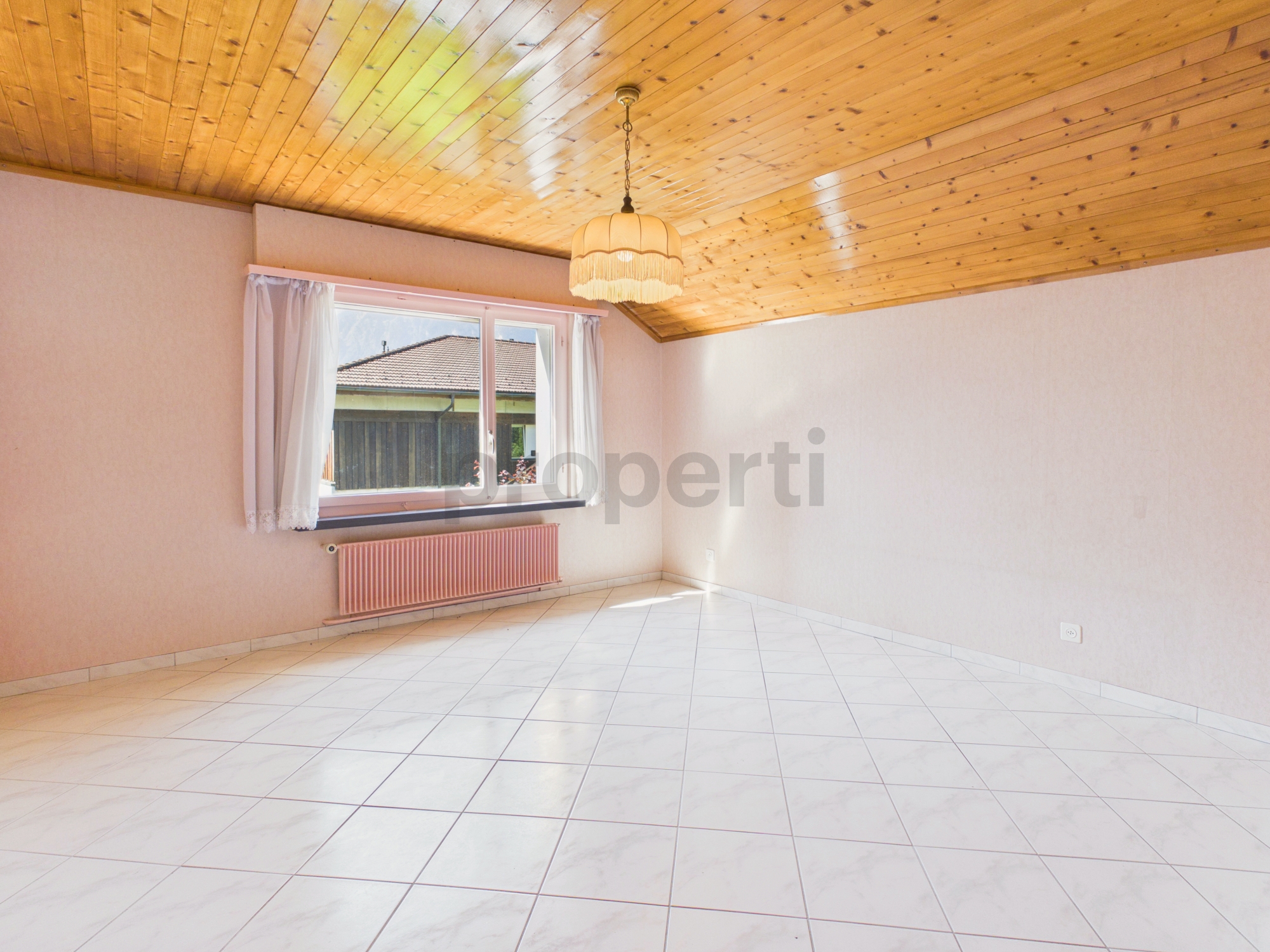Heller leerer Raum mit Holzdecke und Fliesenboden