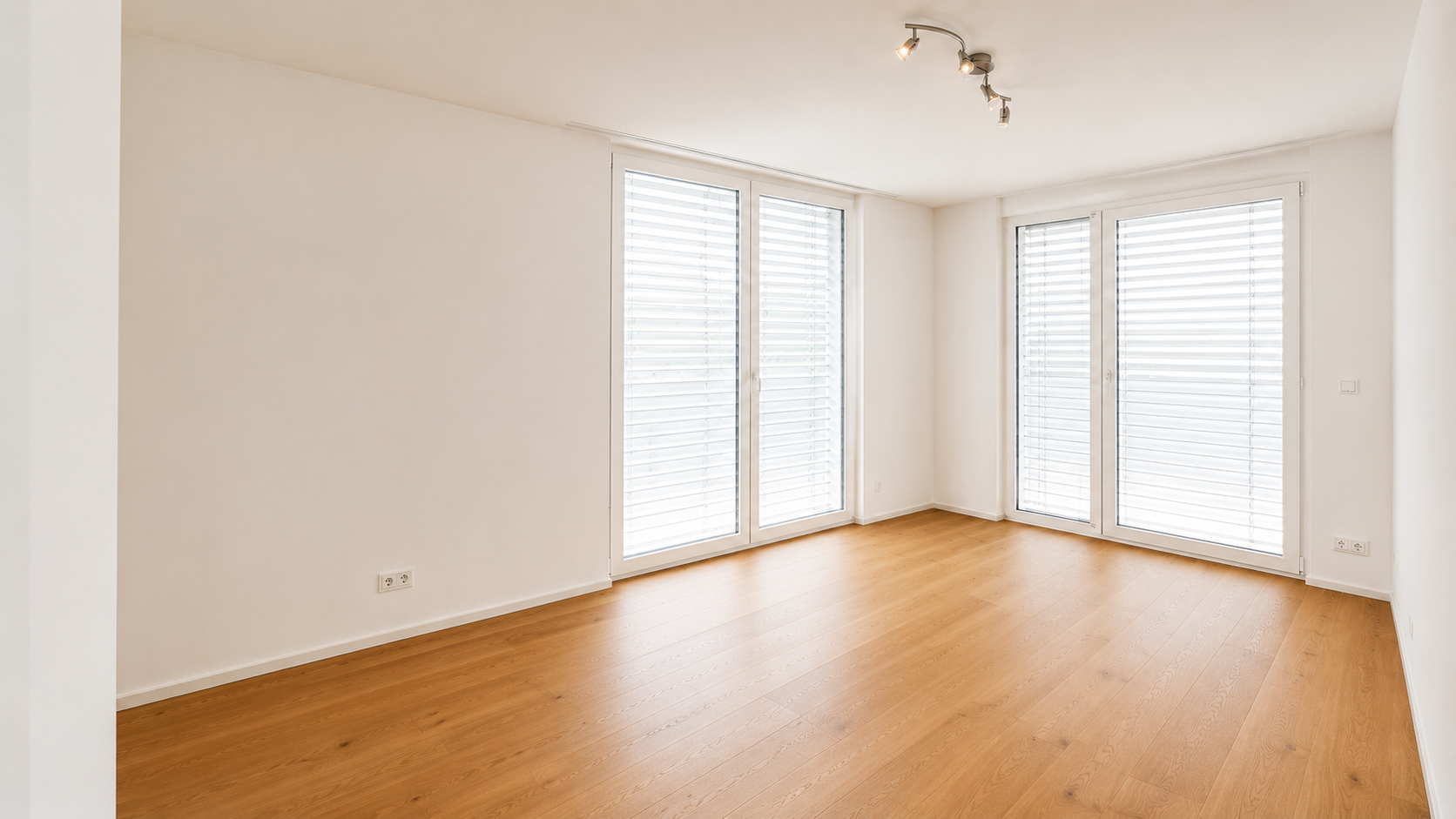 Helles, leeres Zimmer mit großen Fenstern