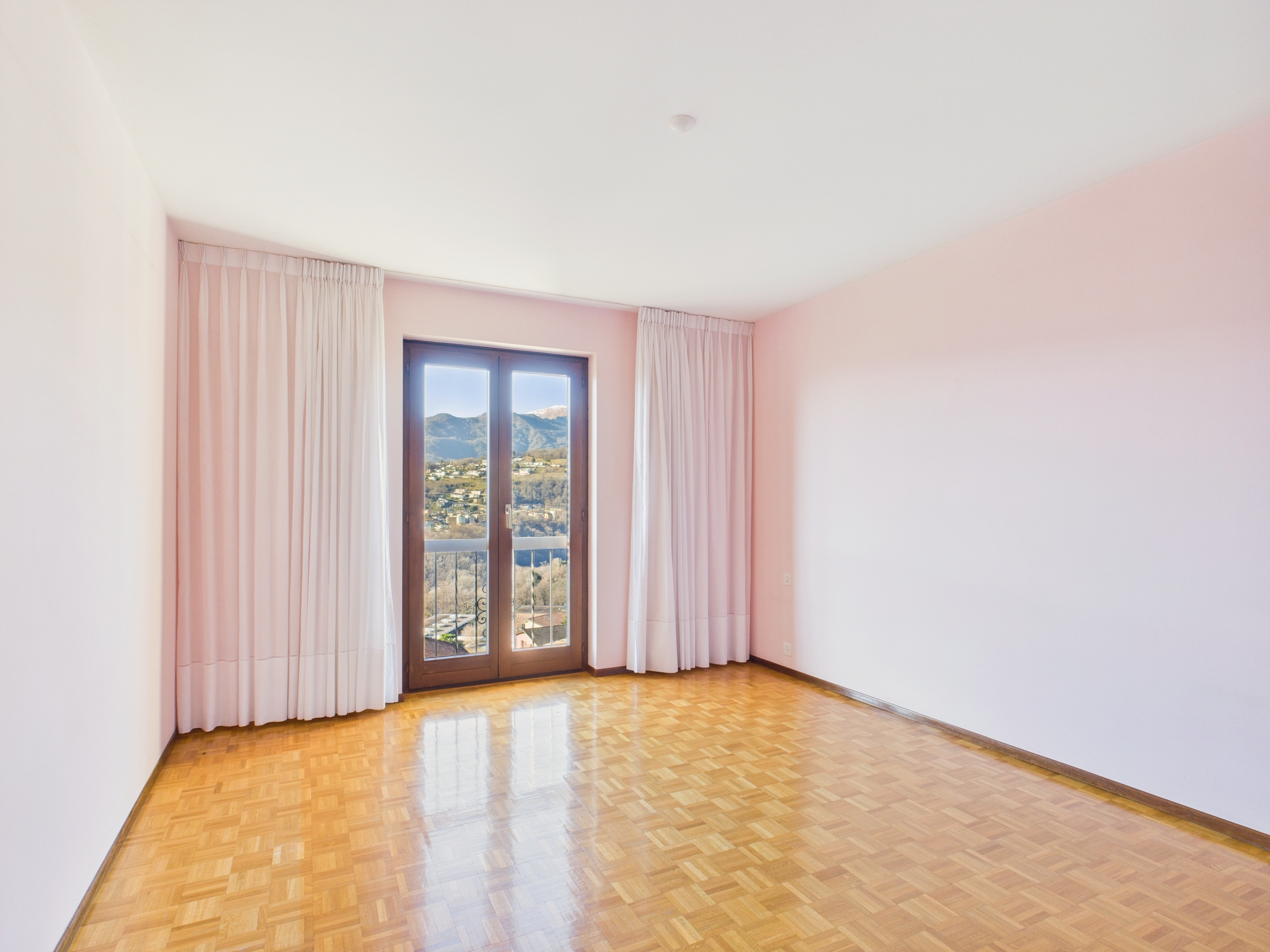 Helles leeres Zimmer mit Balkon- oder Fenstertür und Bergblick