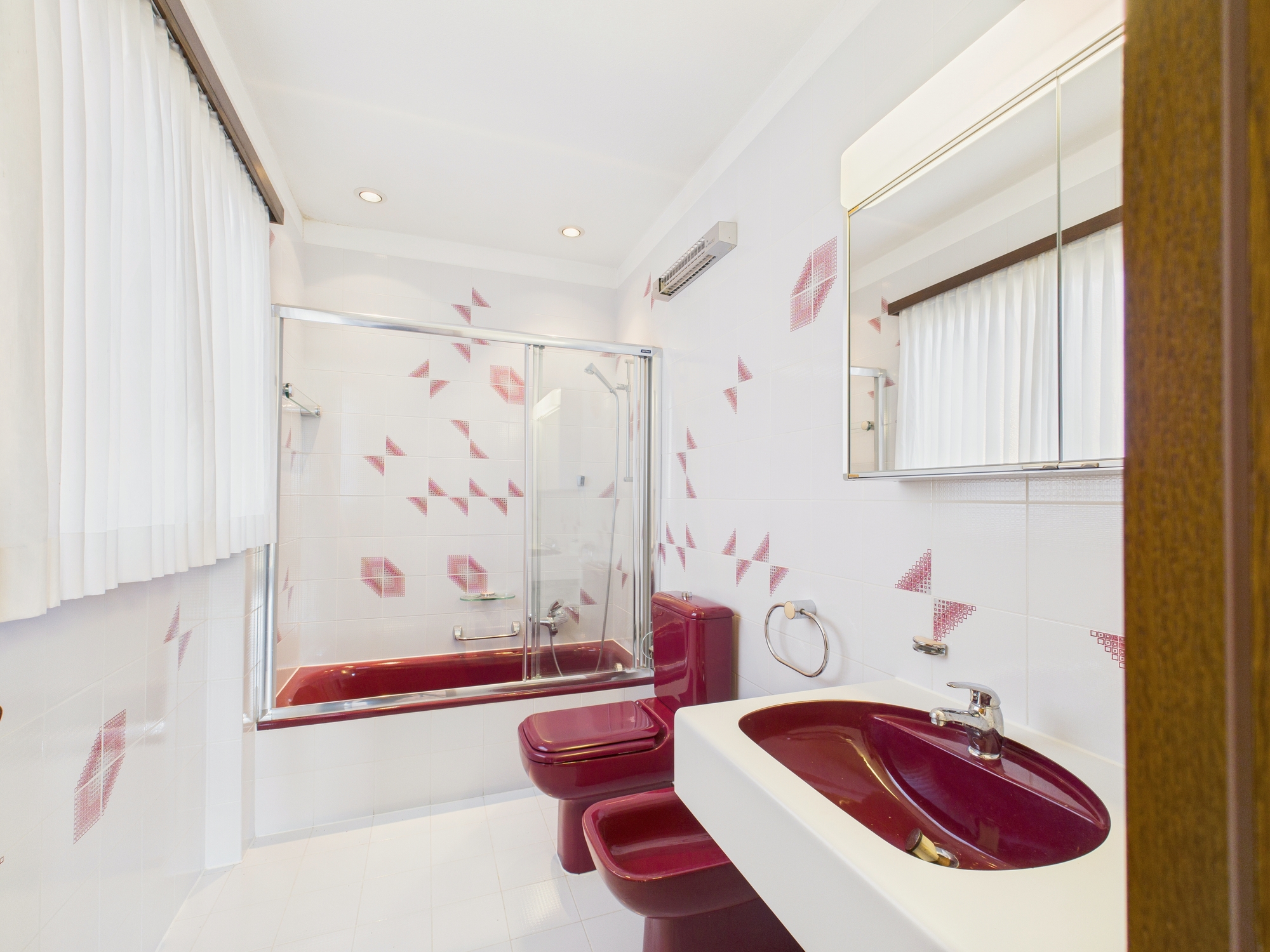 Badezimmer mit Wanne, Dusche und bunten Keramikelementen