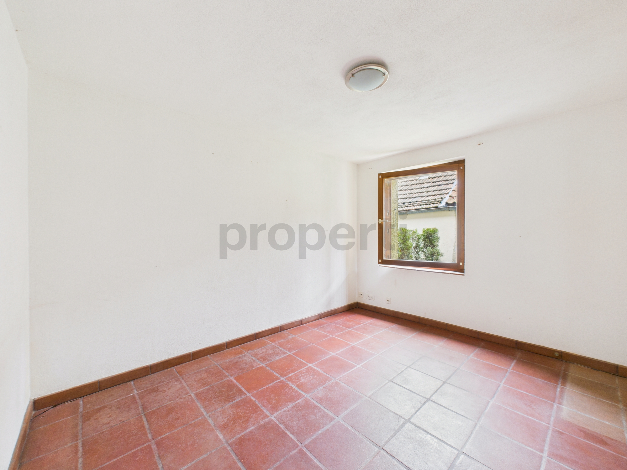Leerer Raum mit Fliesenboden und Fenster