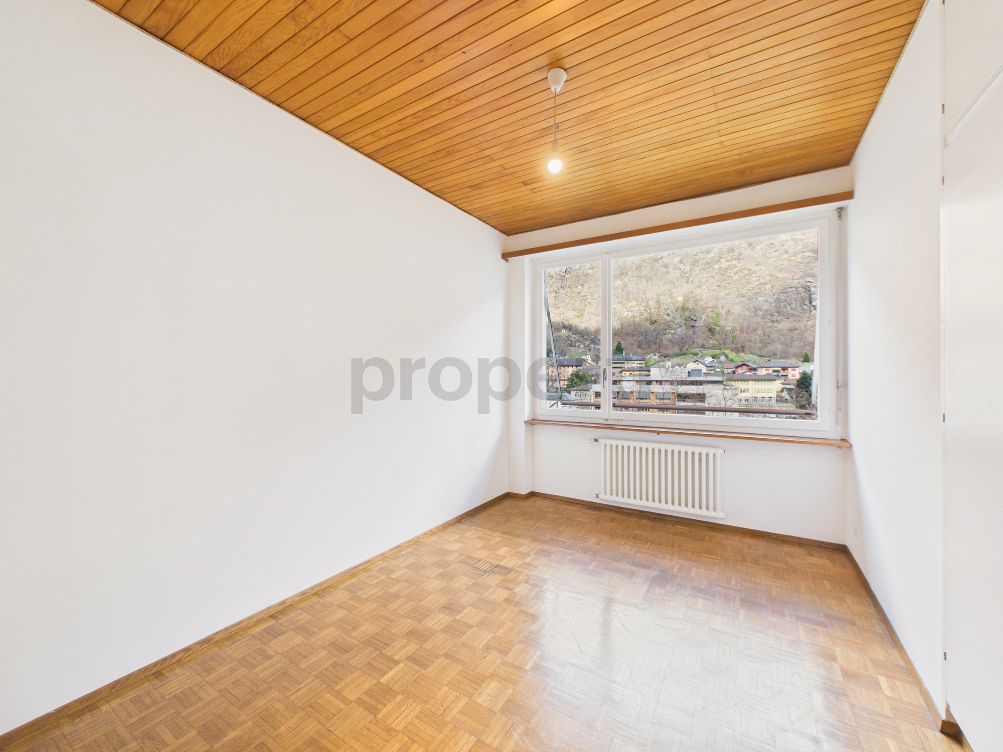 Leerer Wohnraum mit Parkett und Fensterblick