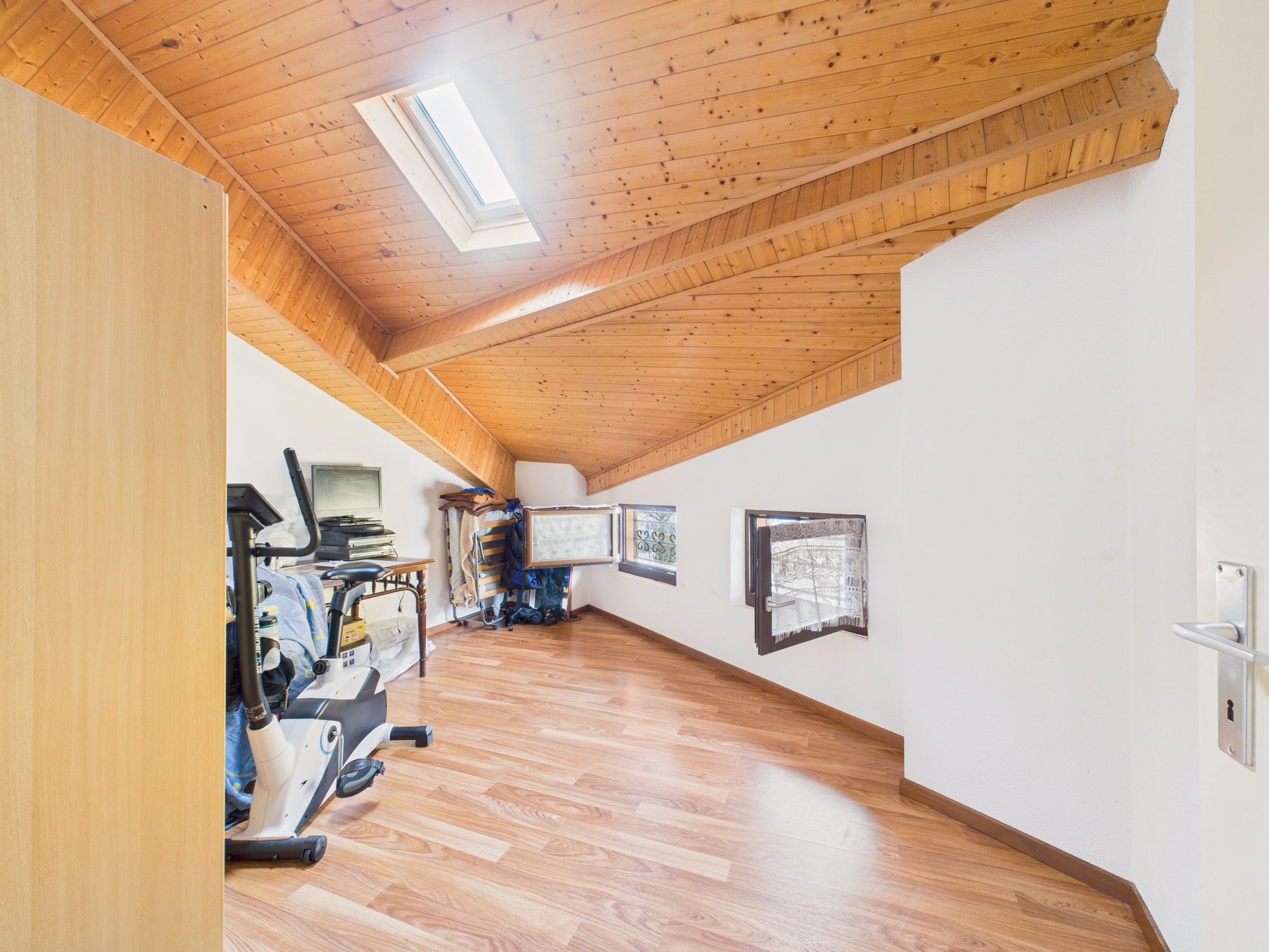 Dachgeschossraum mit Holzdecke und Dachfenster