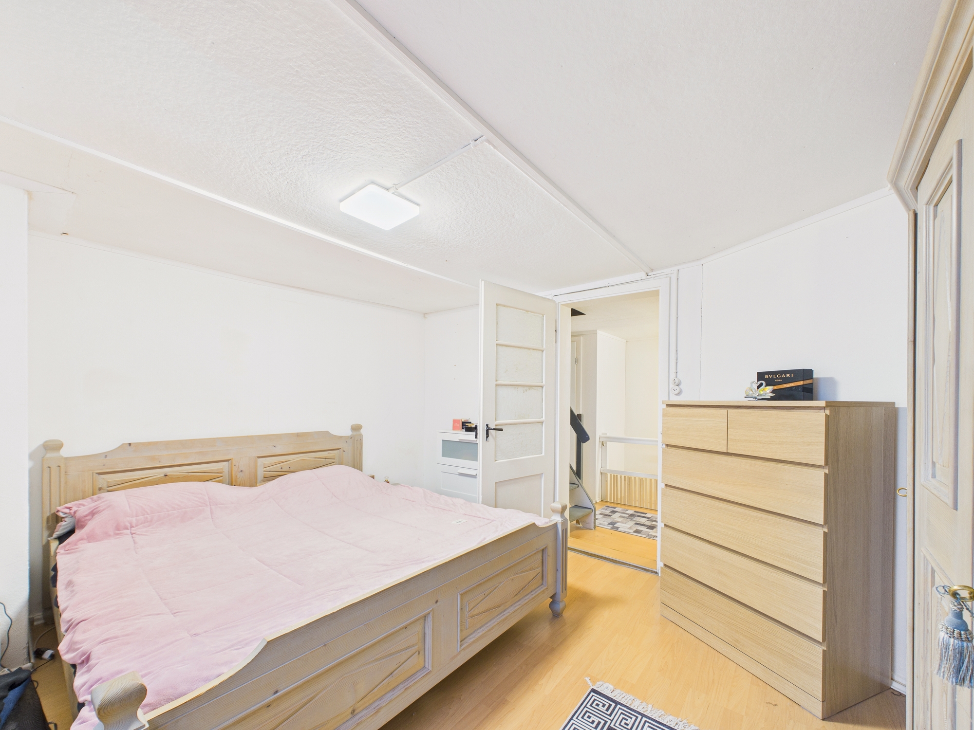Helles Schlafzimmer mit Doppelbett und Kommode
