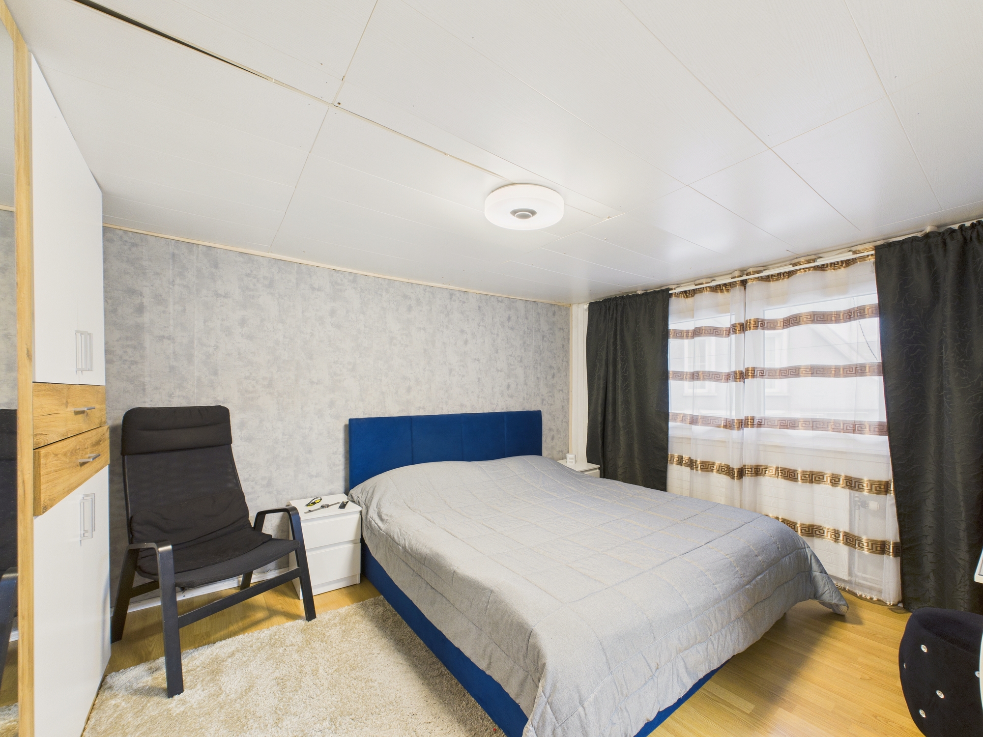 Schlafzimmer mit Bett und Sessel