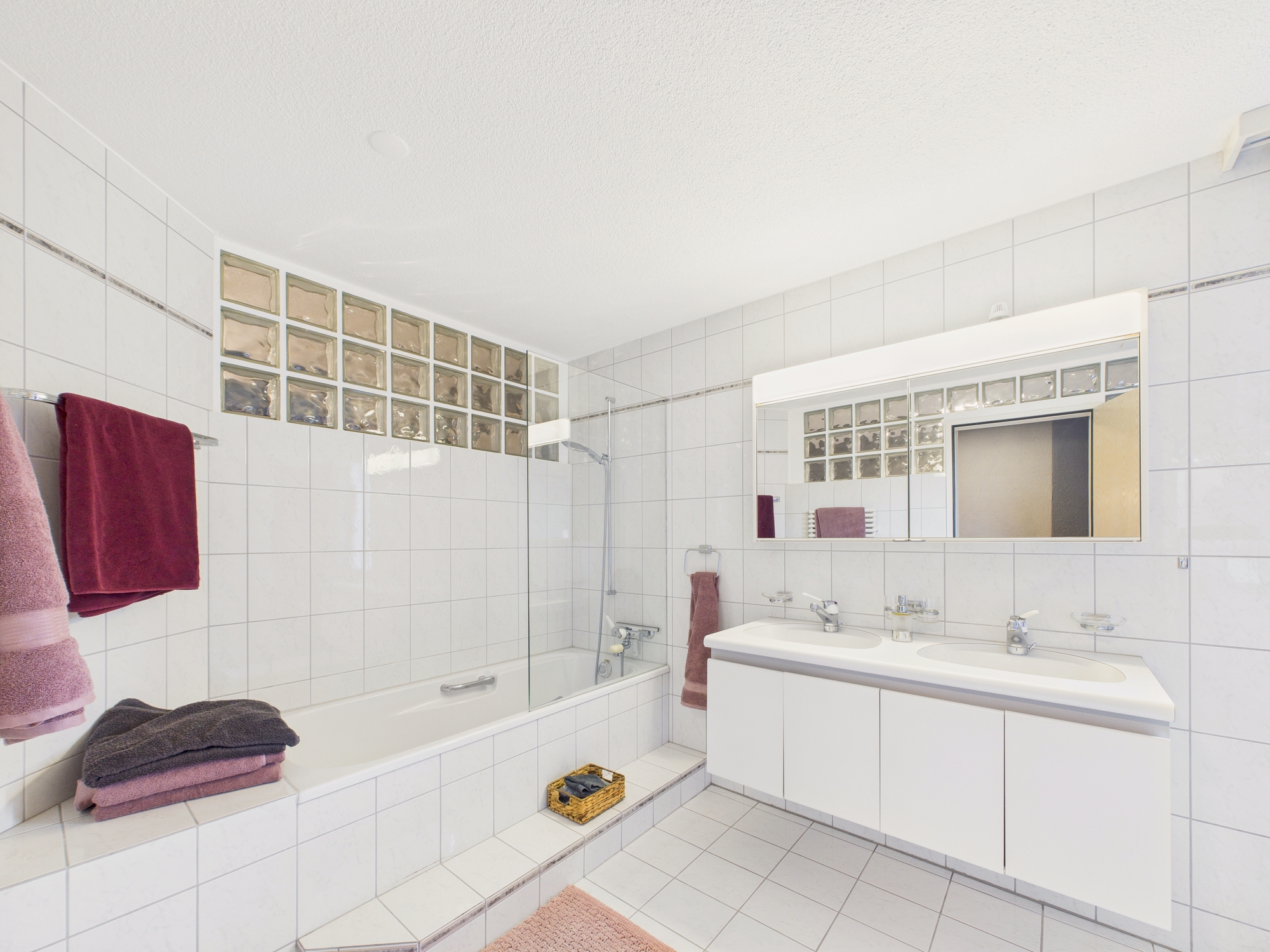 Helles Badezimmer mit Badewanne und Doppelwaschtisch