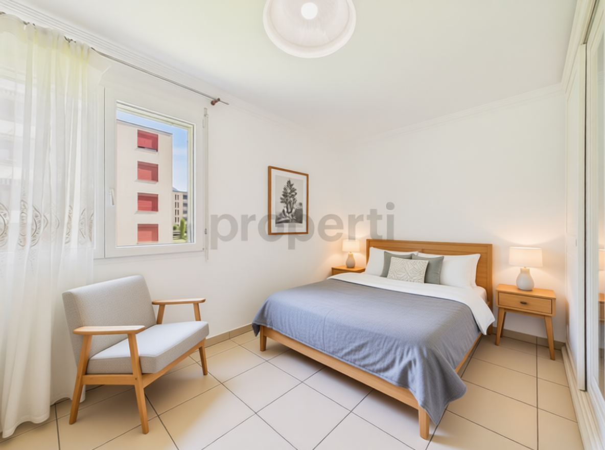 Helles Schlafzimmer mit Doppelbett und Sesselsitz