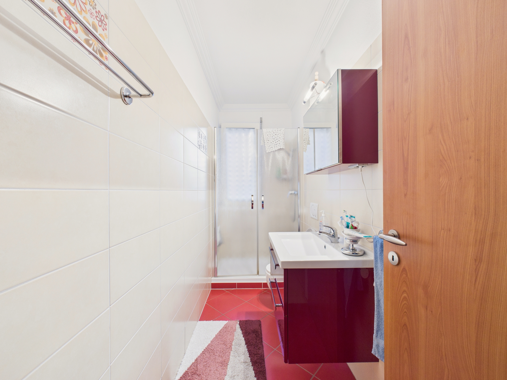 Schmales Badezimmer mit Dusche und Waschtisch