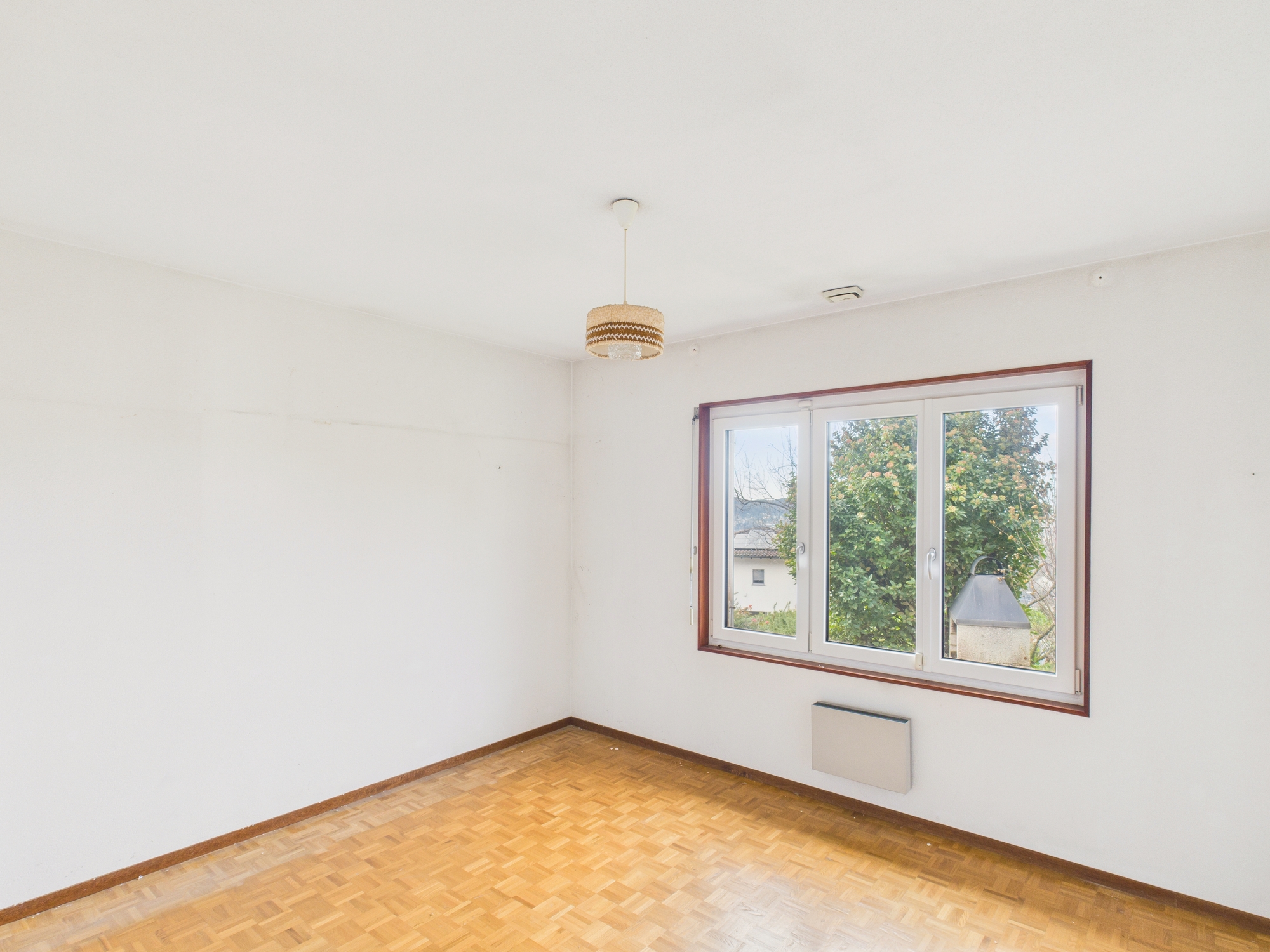 Helles, leeres Zimmer mit Parquetboden