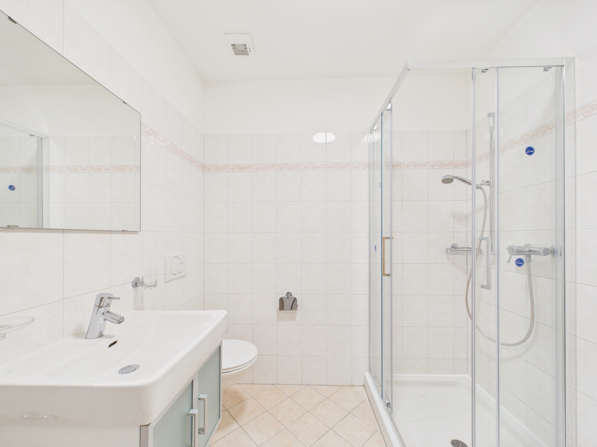 Helles, modernes Badezimmer mit Dusche und Waschtisch
