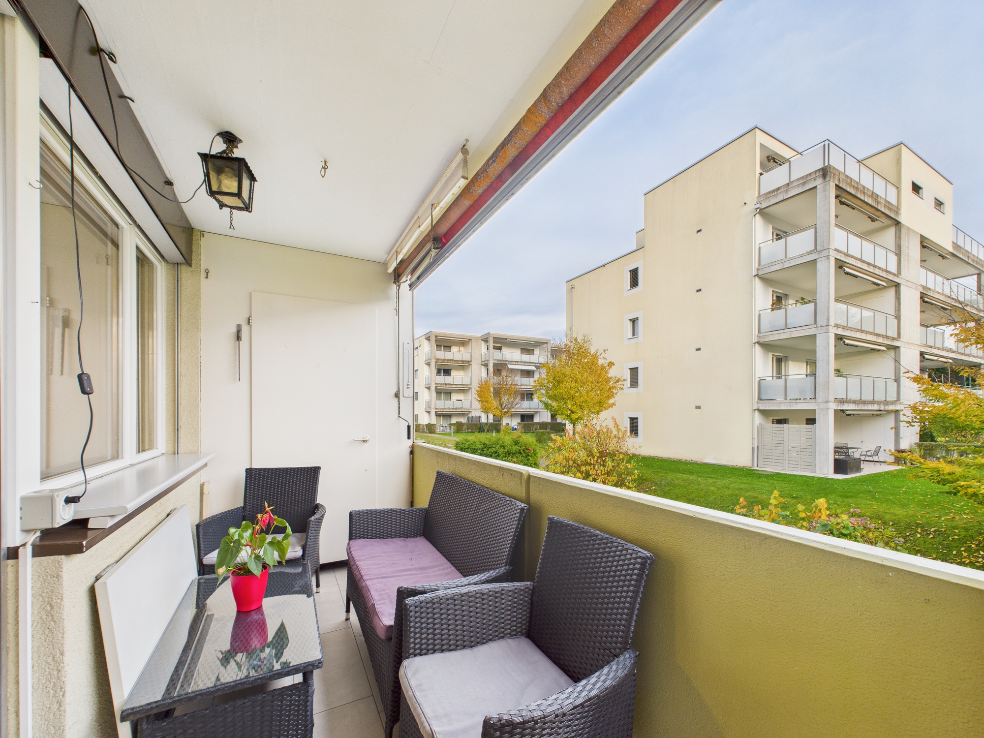 Balkon mit Sitzgruppe und Blick auf Wohnanlage