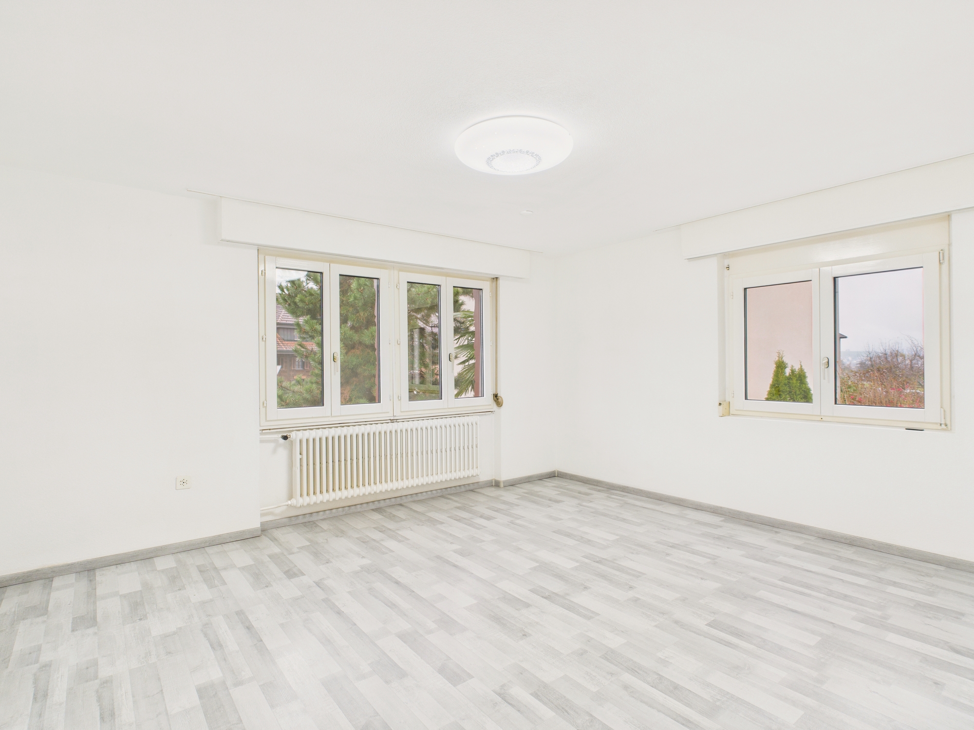 Heller leerer Wohnraum mit zwei Fenstern