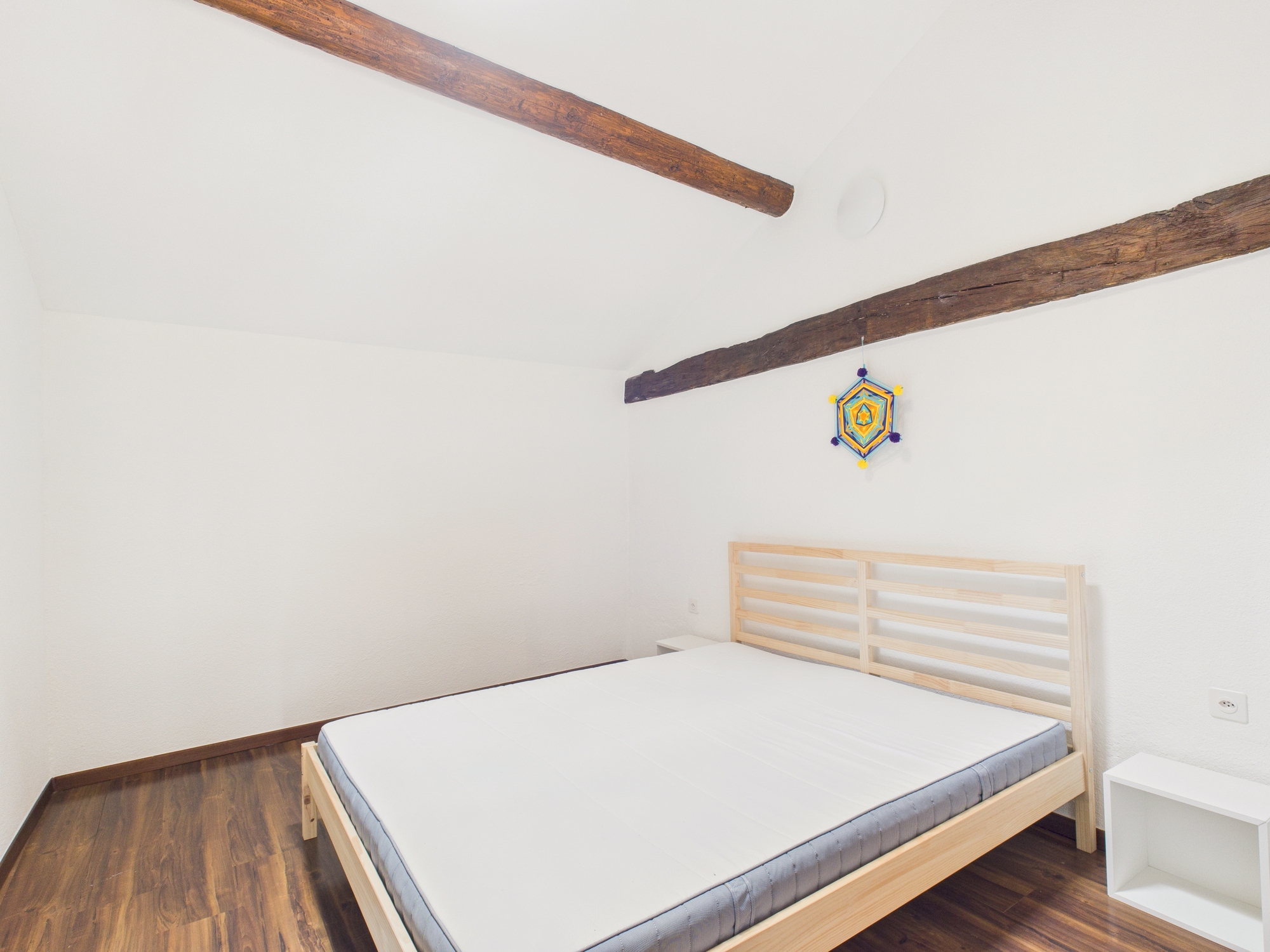 Minimalistisches Schlafzimmer mit sichtbaren Holzbalken