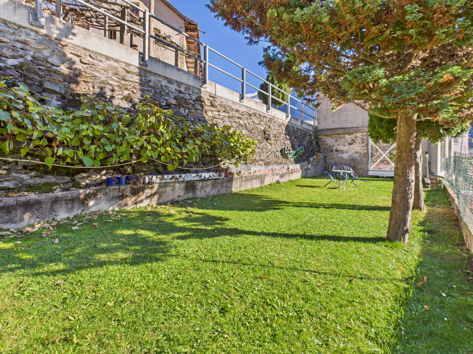 Garten mit Steinmauer und Rasen
