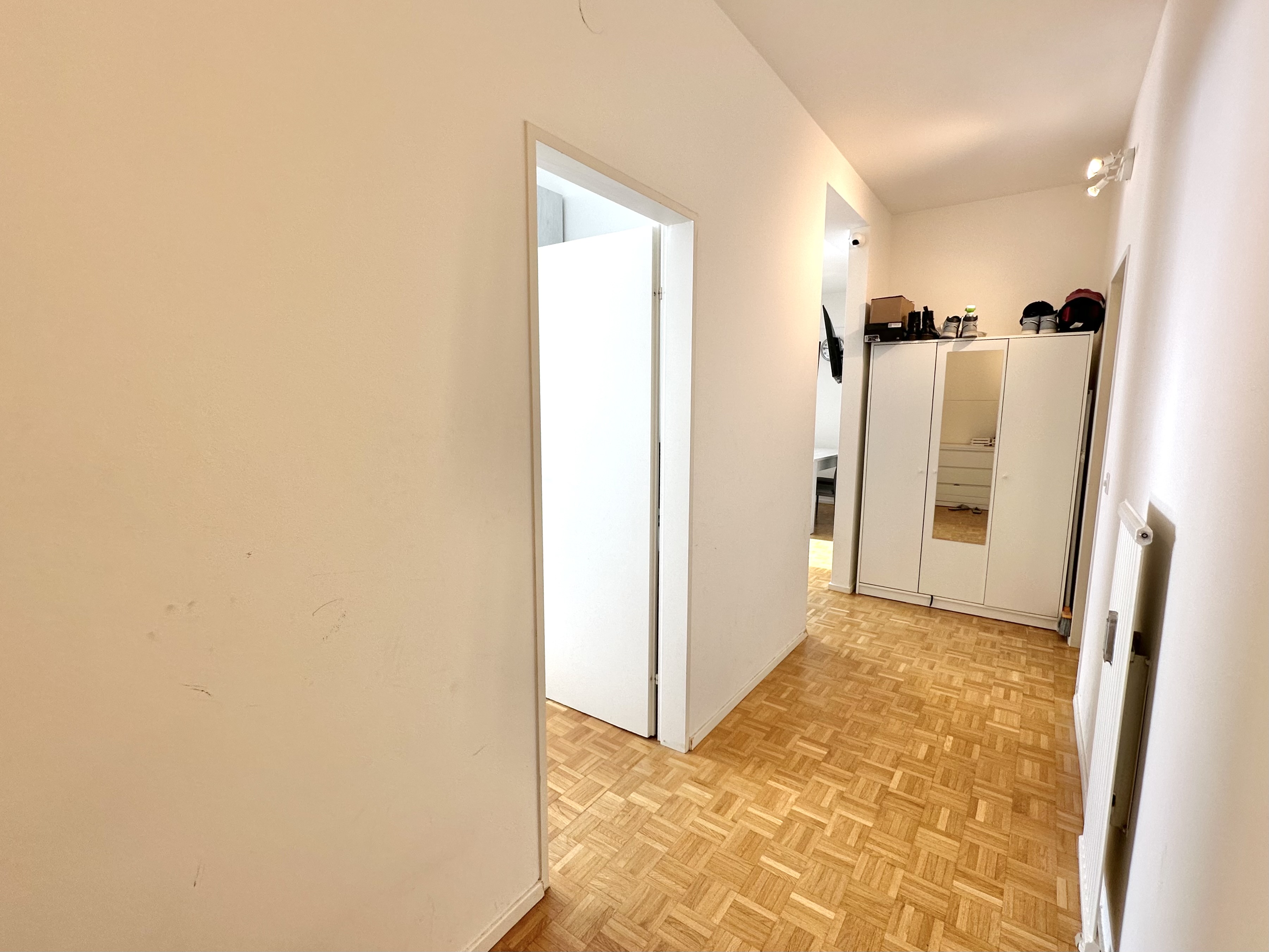 Heller Flur mit Parkett und Garderobenschrank