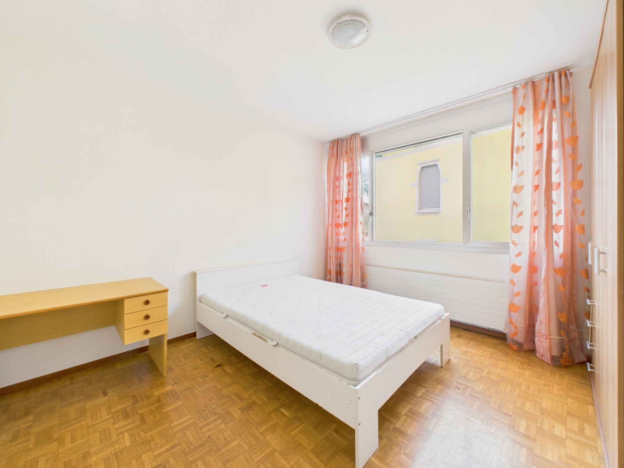 Helles Schlafzimmer mit Einzelbett und Schreibtisch