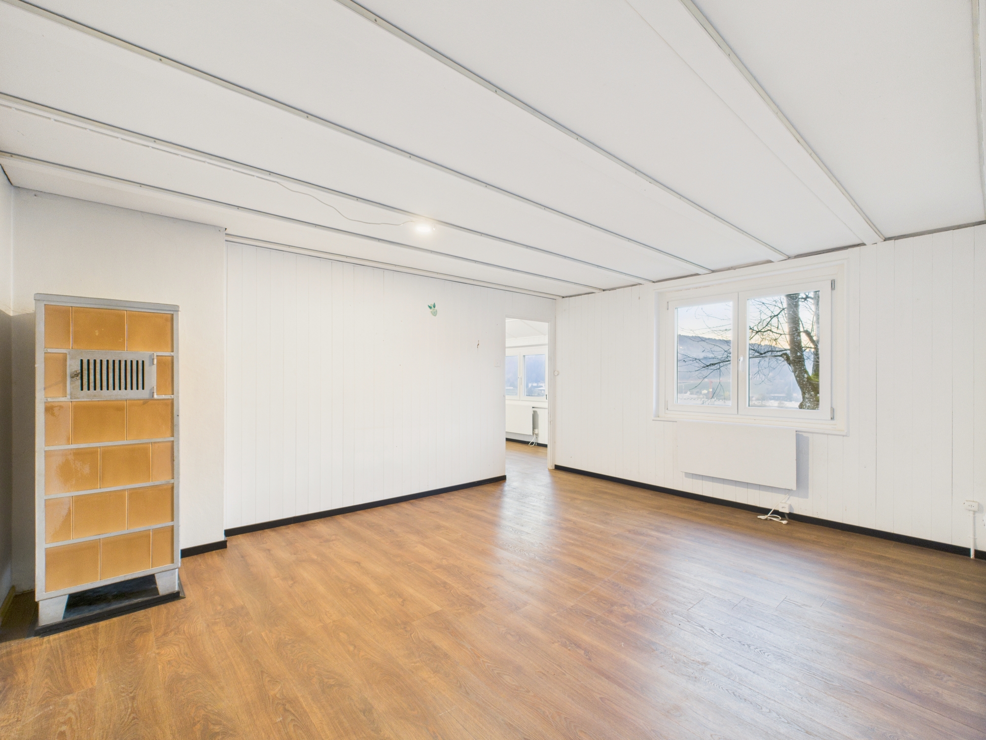 Leerer Wohnraum mit Kachelofen
