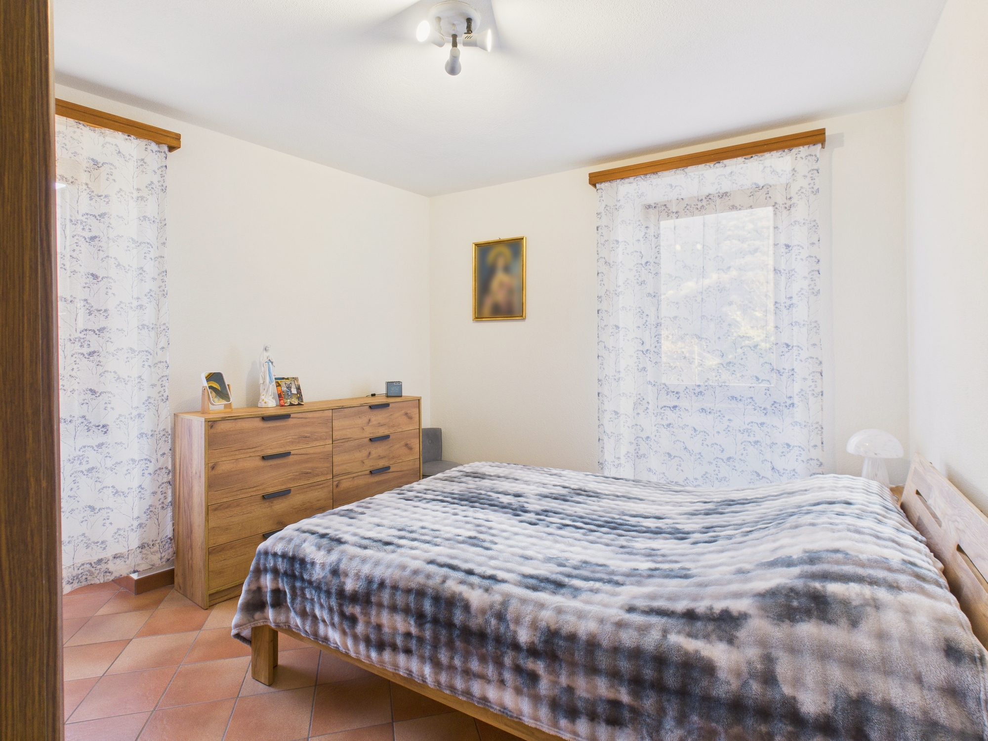 Schlafzimmer mit Fliesenboden und rustikalen Holzmöbeln