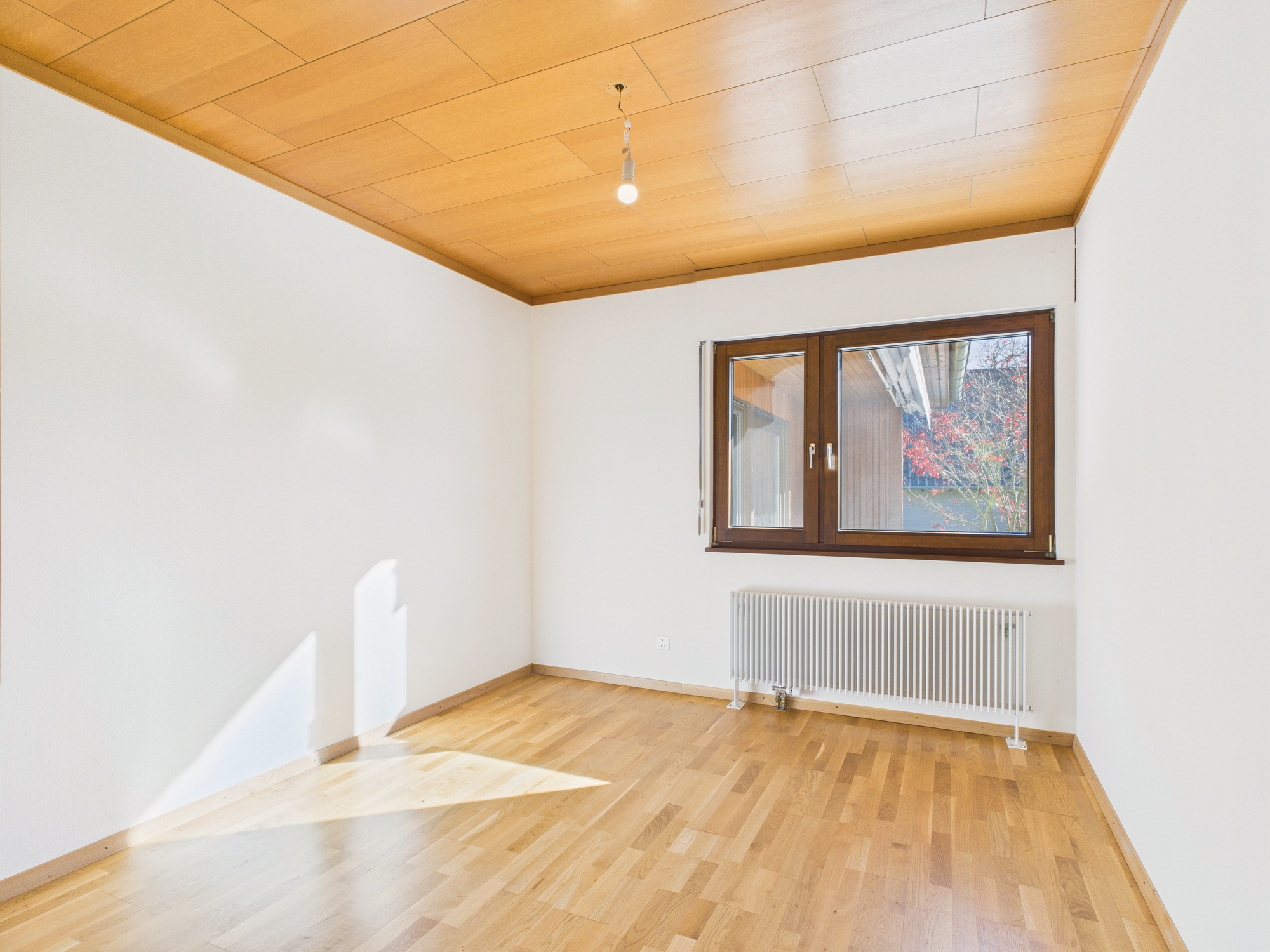 Heller leerer Raum mit Holzdecke und Parkett