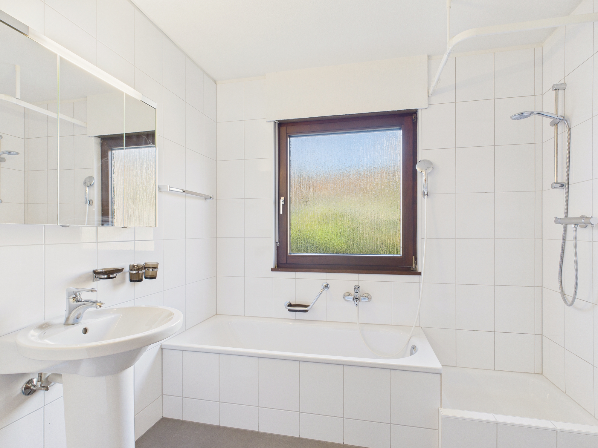 Helles Badezimmer mit Badewanne und Dusche