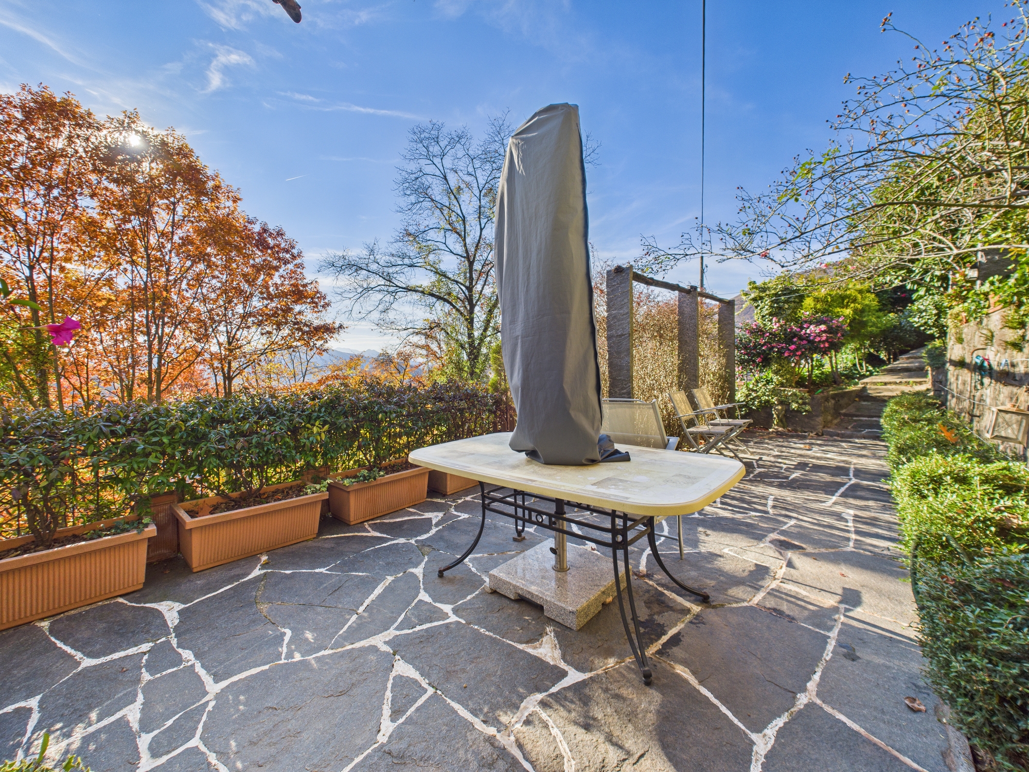 Terrasse mit Gartenmöbeln und Blick ins Grüne