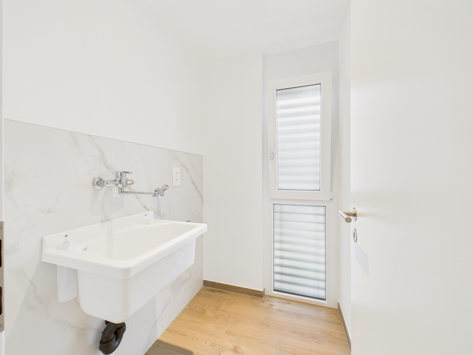 Helles Badezimmer mit Waschtisch und schmalem Fenster