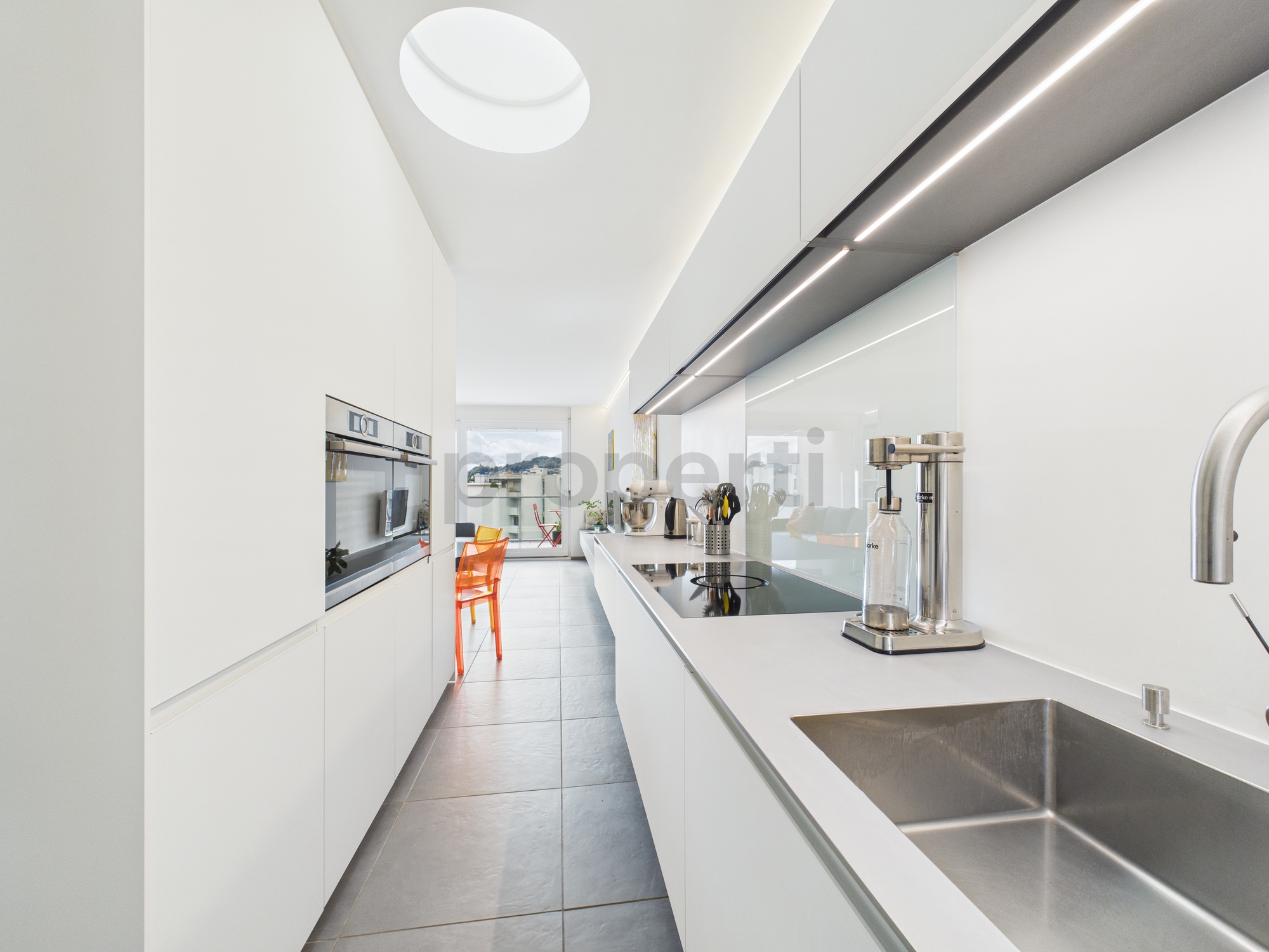 Moderne, schmale Design-Küche mit Blick zum Balkon