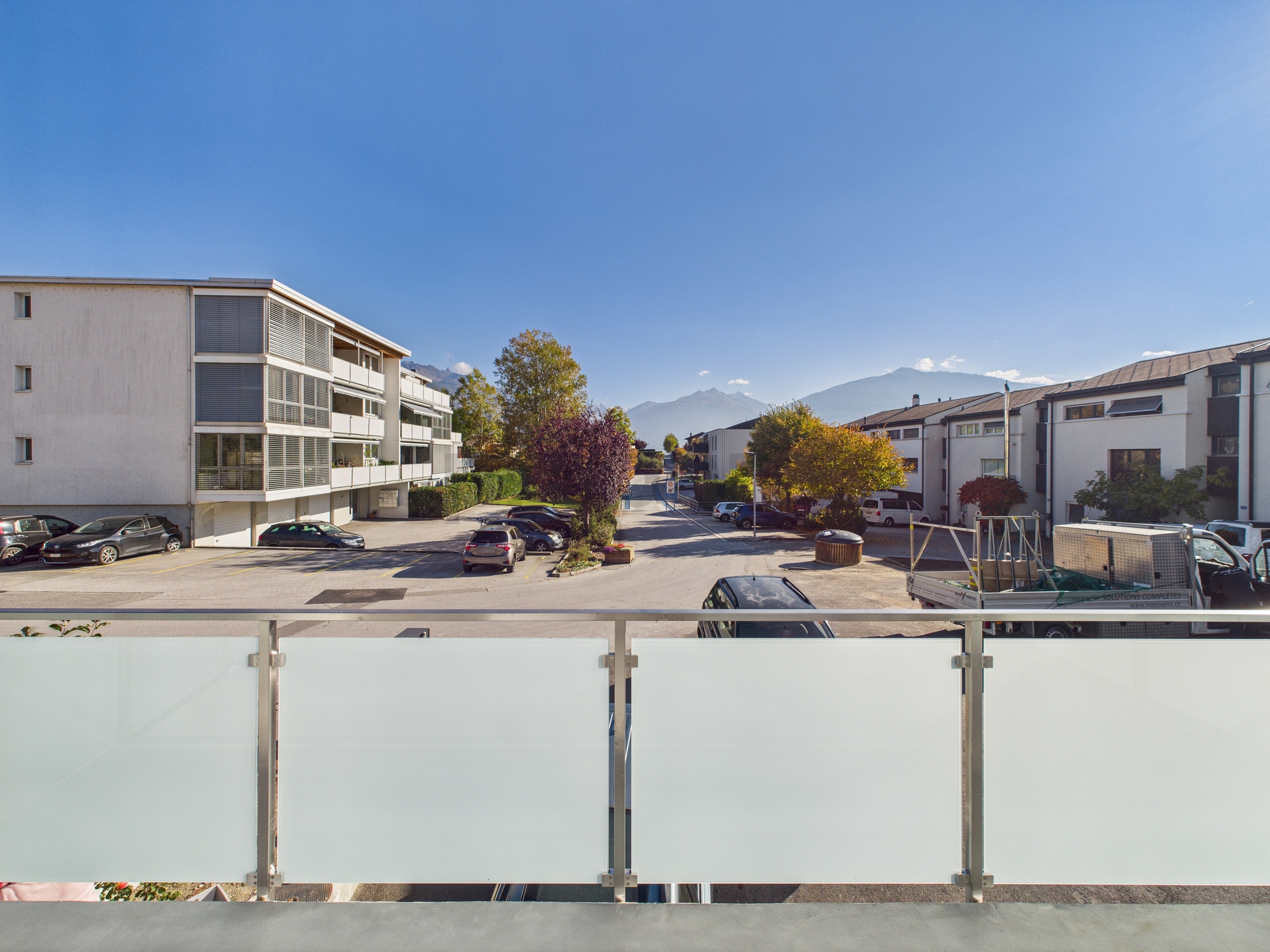 Blick vom Balkon auf Wohnstraße und Berge