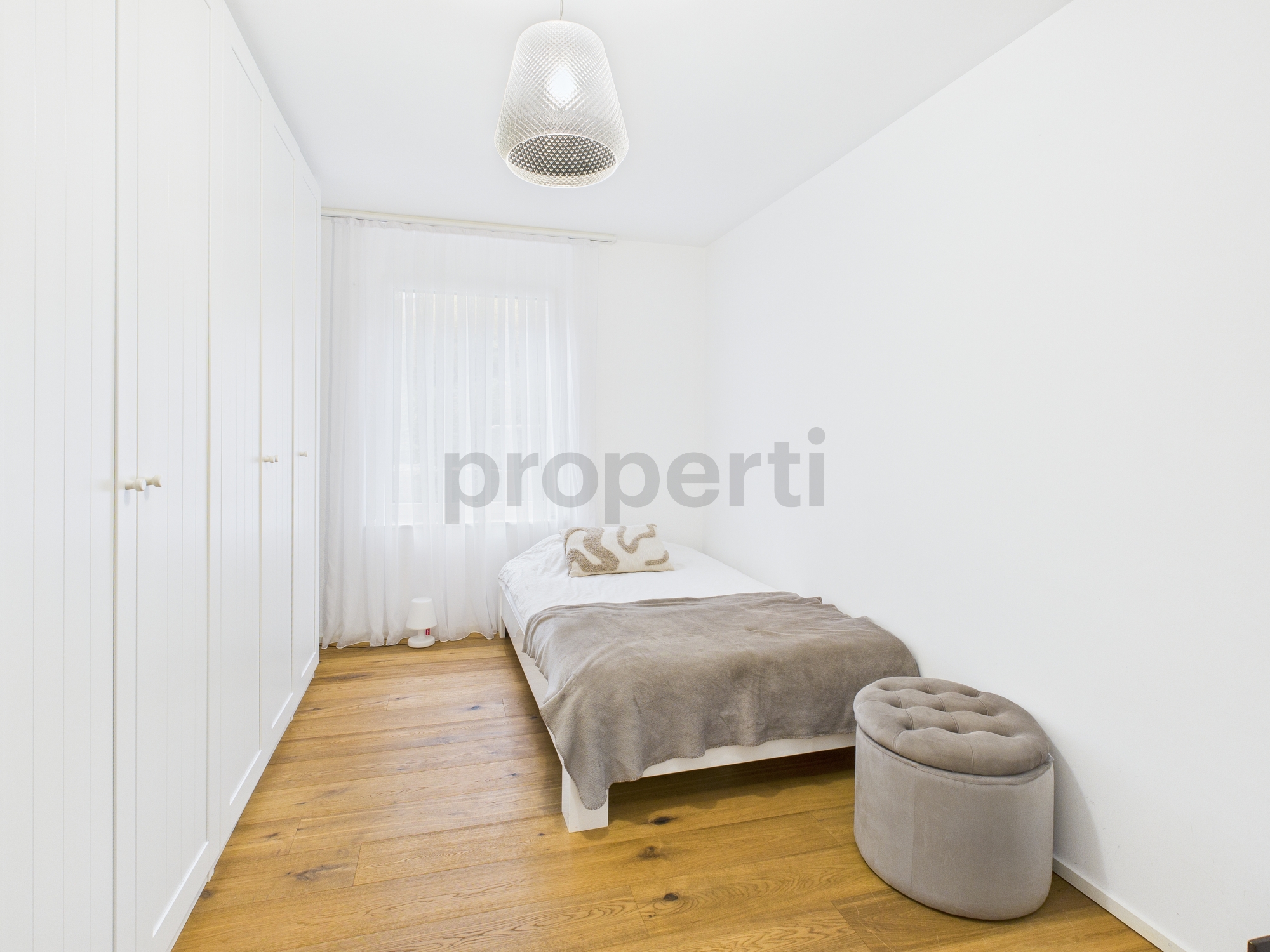 Helles, schmales Schlafzimmer mit Einzelbett und Einbauschrank