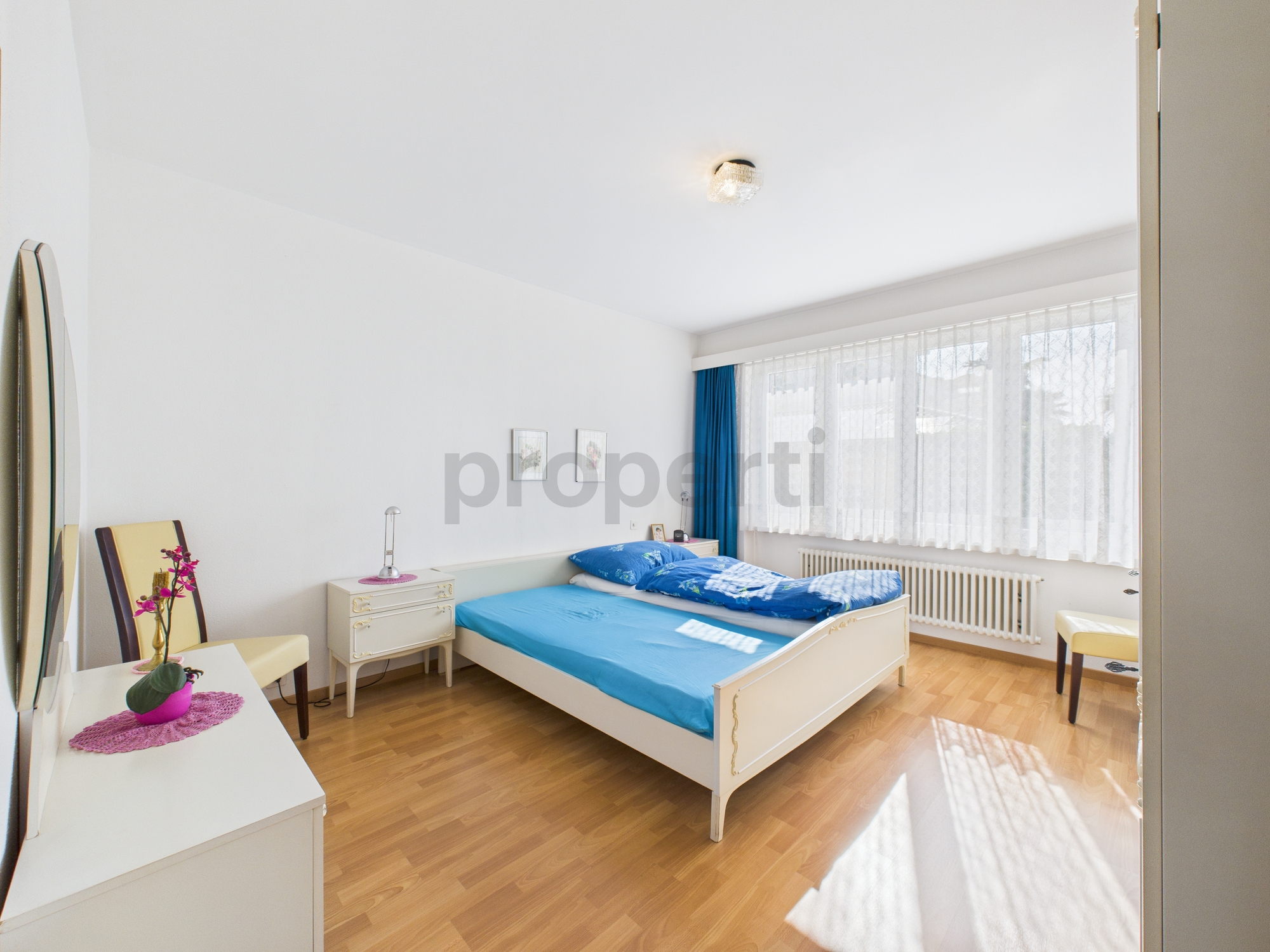 Helles Schlafzimmer mit blauem Bettzeug