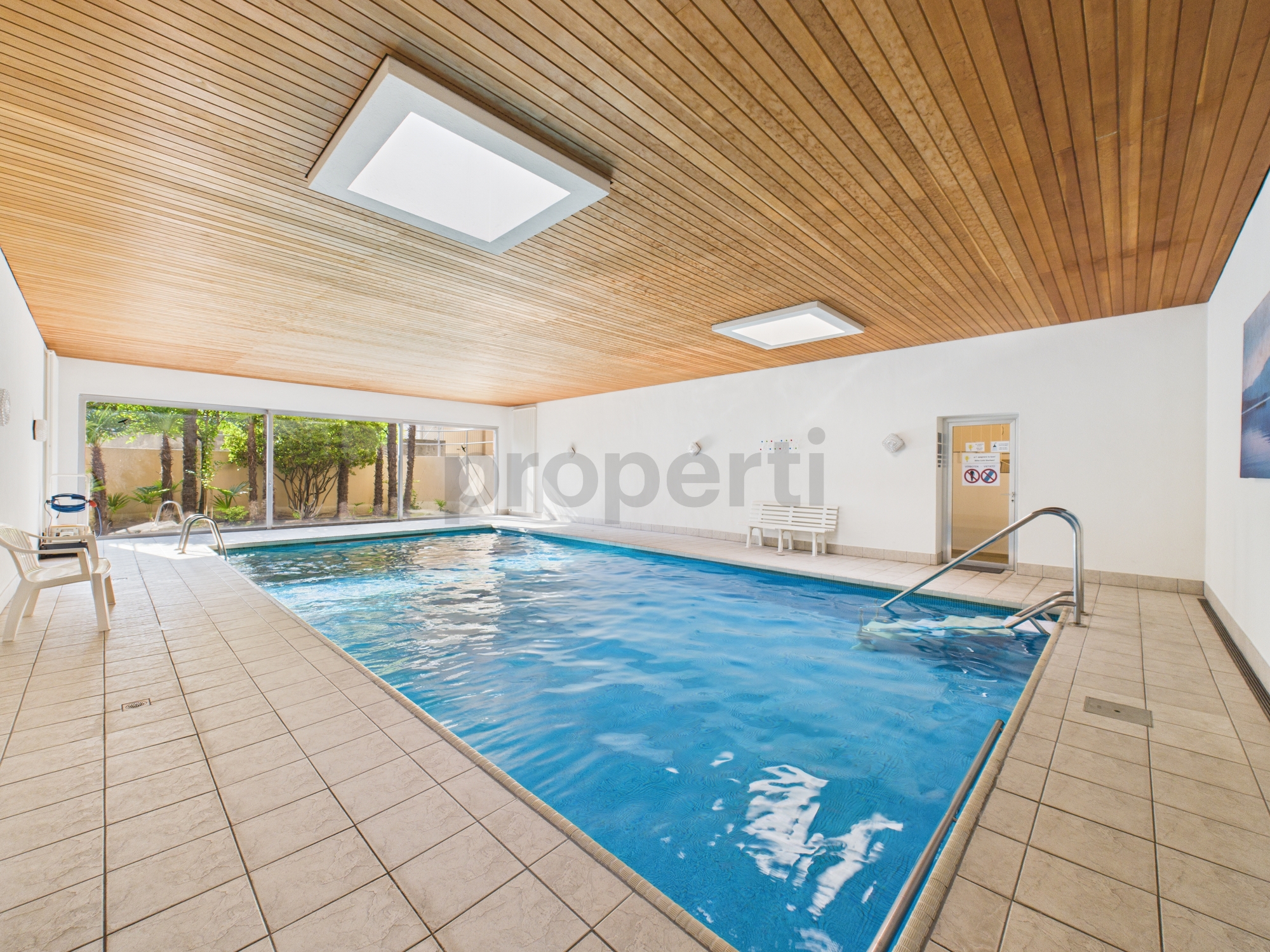Innenpool mit Holzdecke und Fliesen