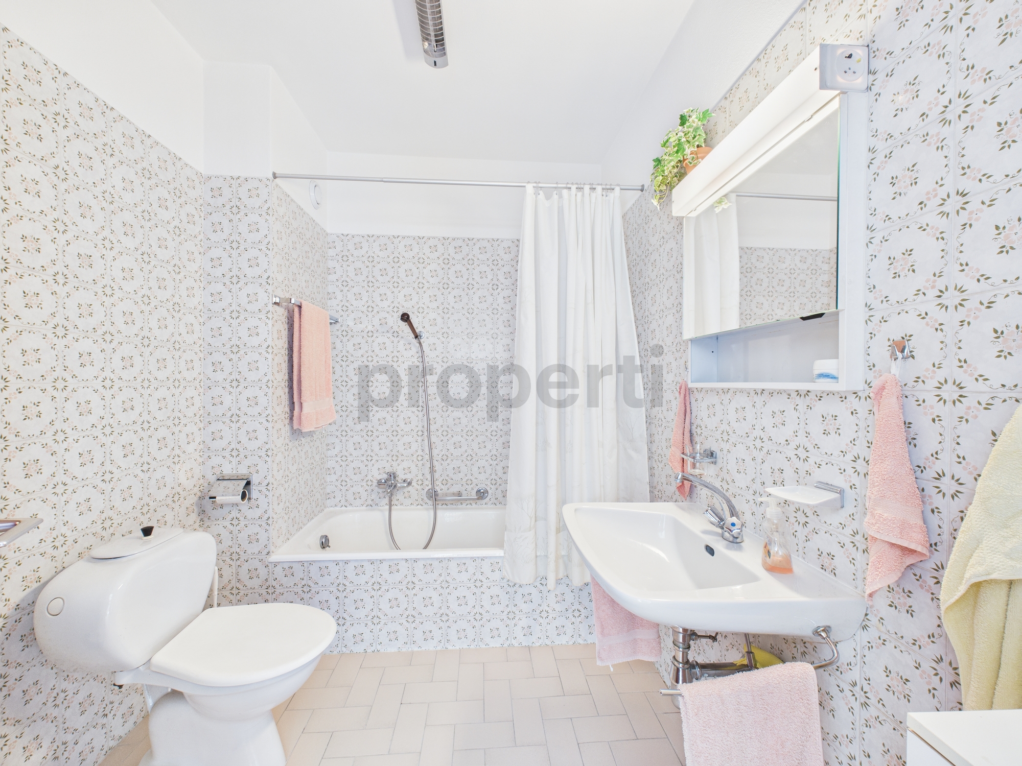 Helles Badezimmer mit Badewanne, WC und Waschtisch